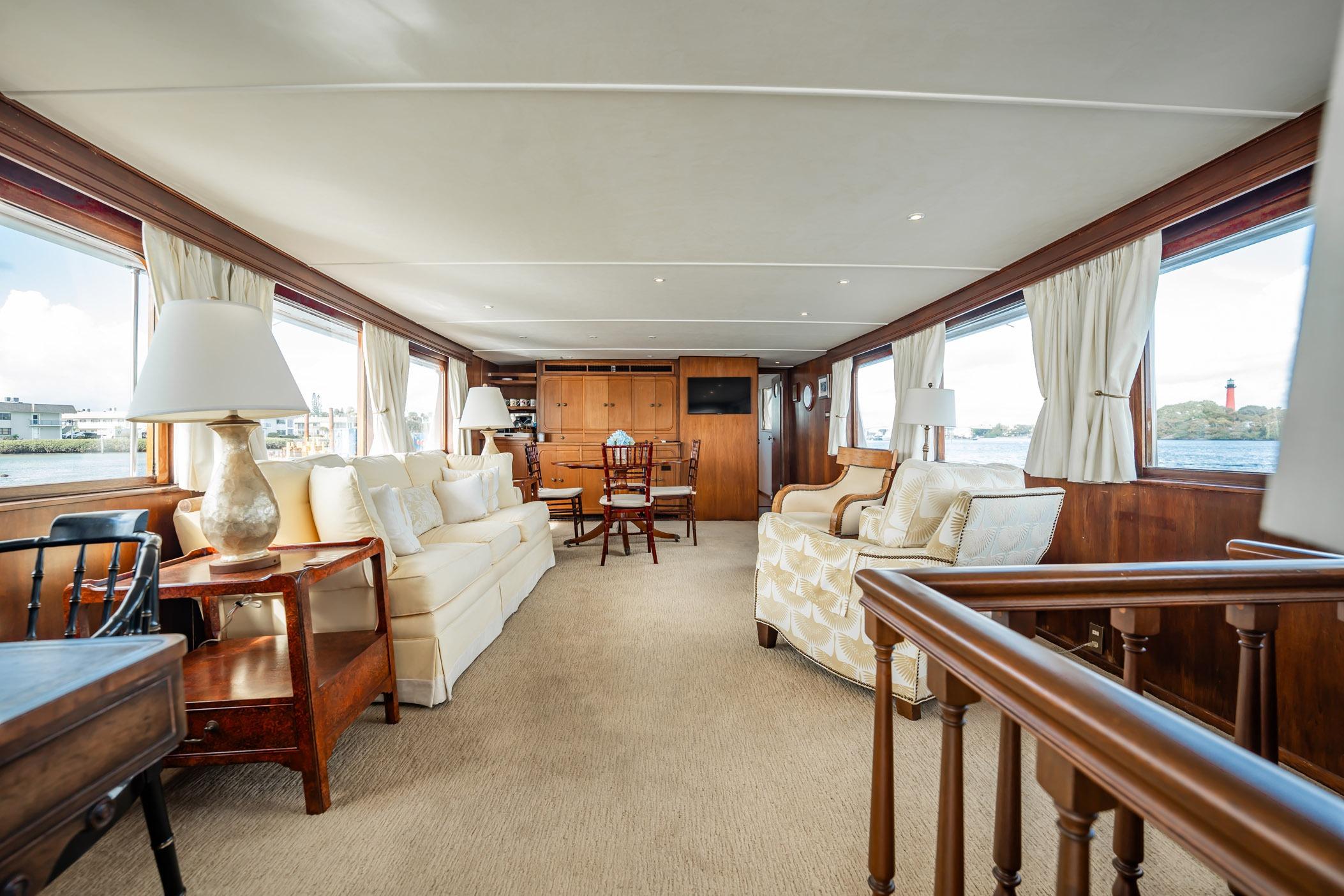 Luxurious interior of 1972 Trumpy 72 Motor Yacht with elegant furnishings and panoramic windows.