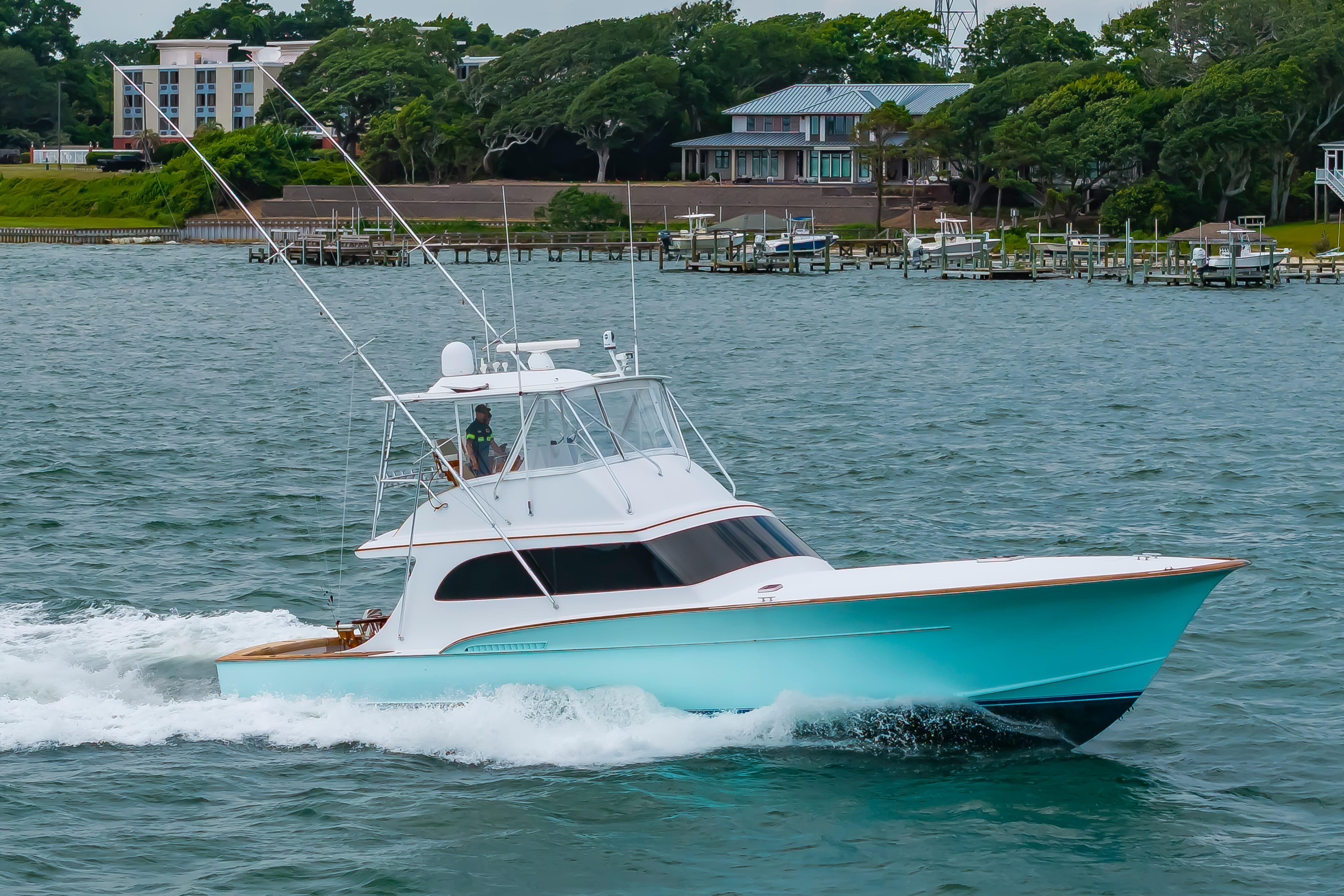 1993 Custom Carolina Scarborough 56 Convertible yacht cruising on a scenic waterway.