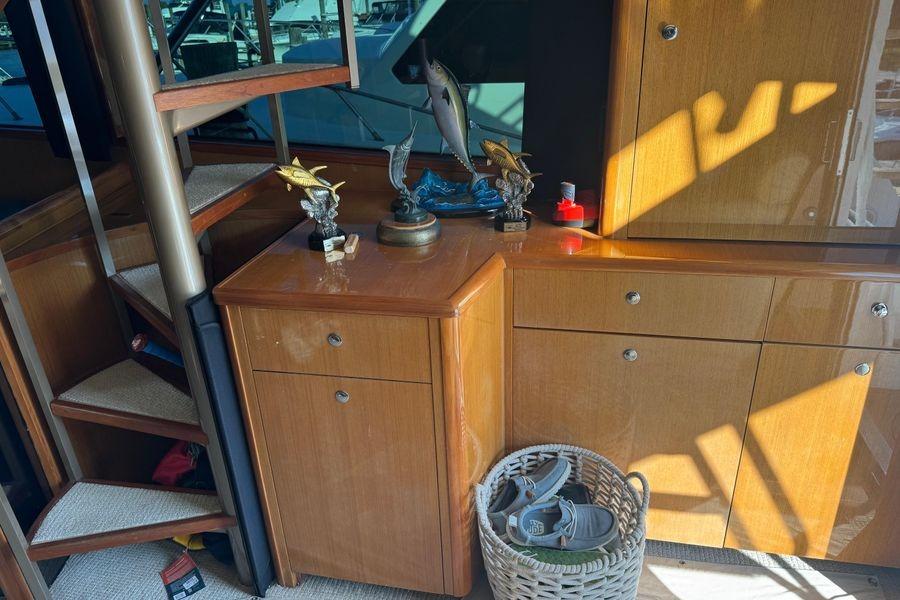 Interior of 2002 Viking 61 Enclosed Bridge with wooden cabinets and decorative fish sculptures.