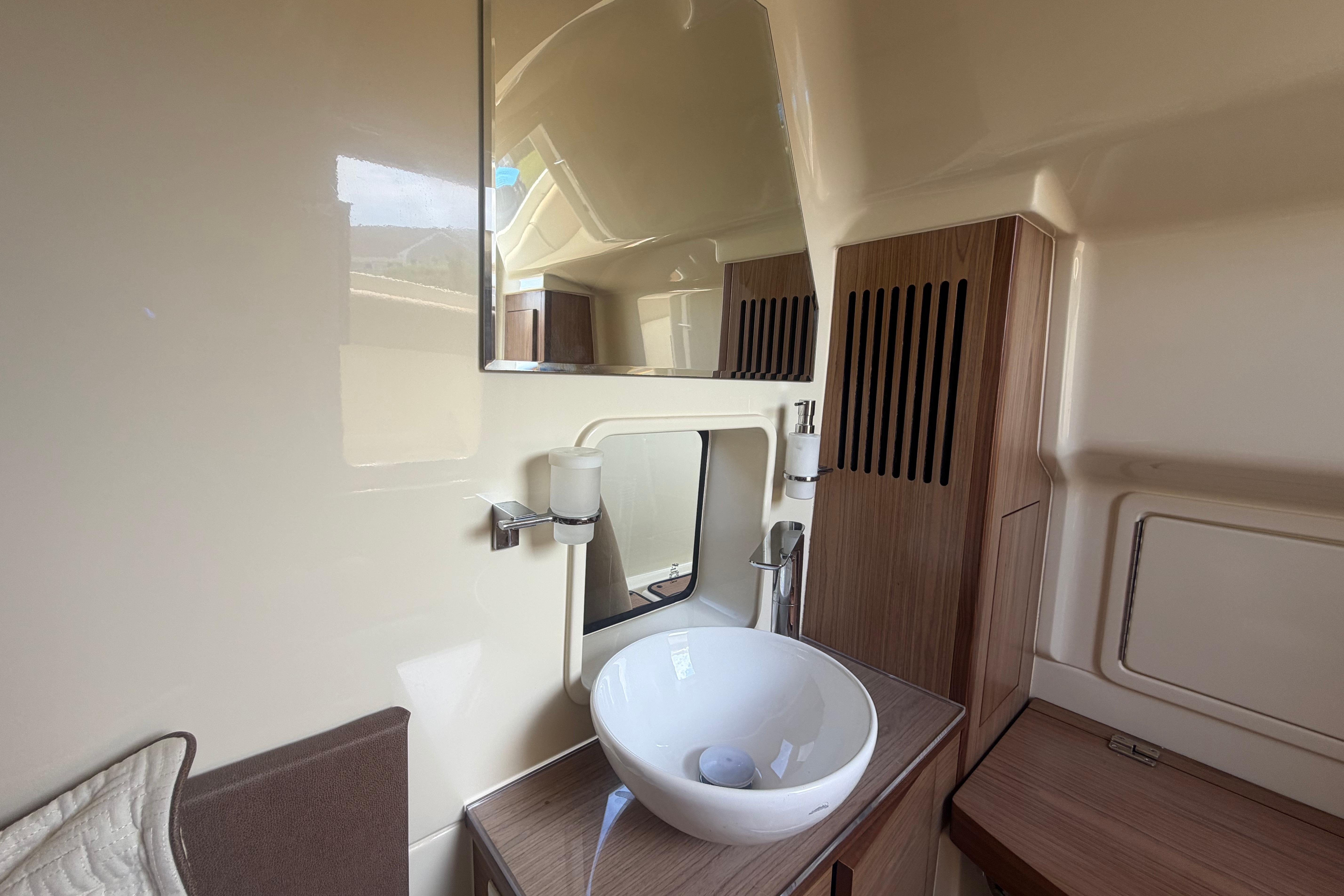 Luxurious bathroom interior of 2017 Chris-Craft Catalina 34 boat with modern sink and mirror.