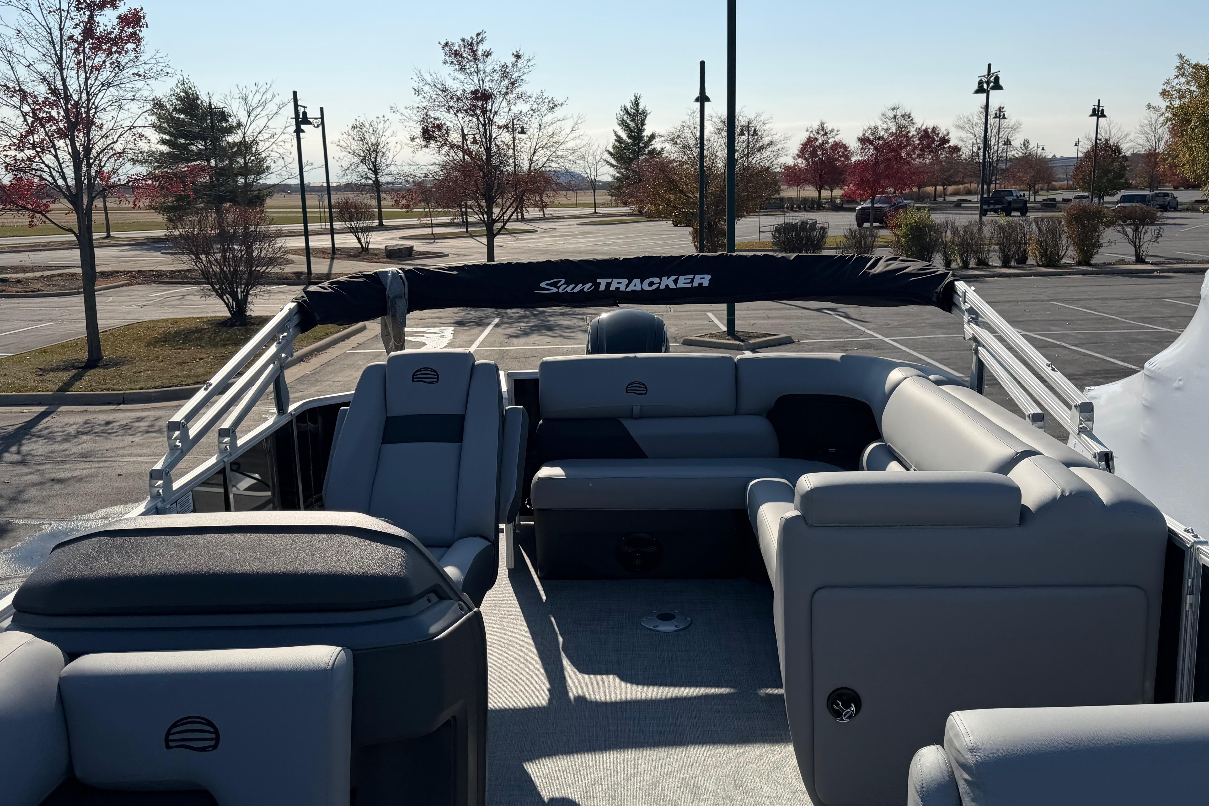 2026 Sun Tracker Party Barge 20 DLX pontoon boat with spacious seating in a parking lot.