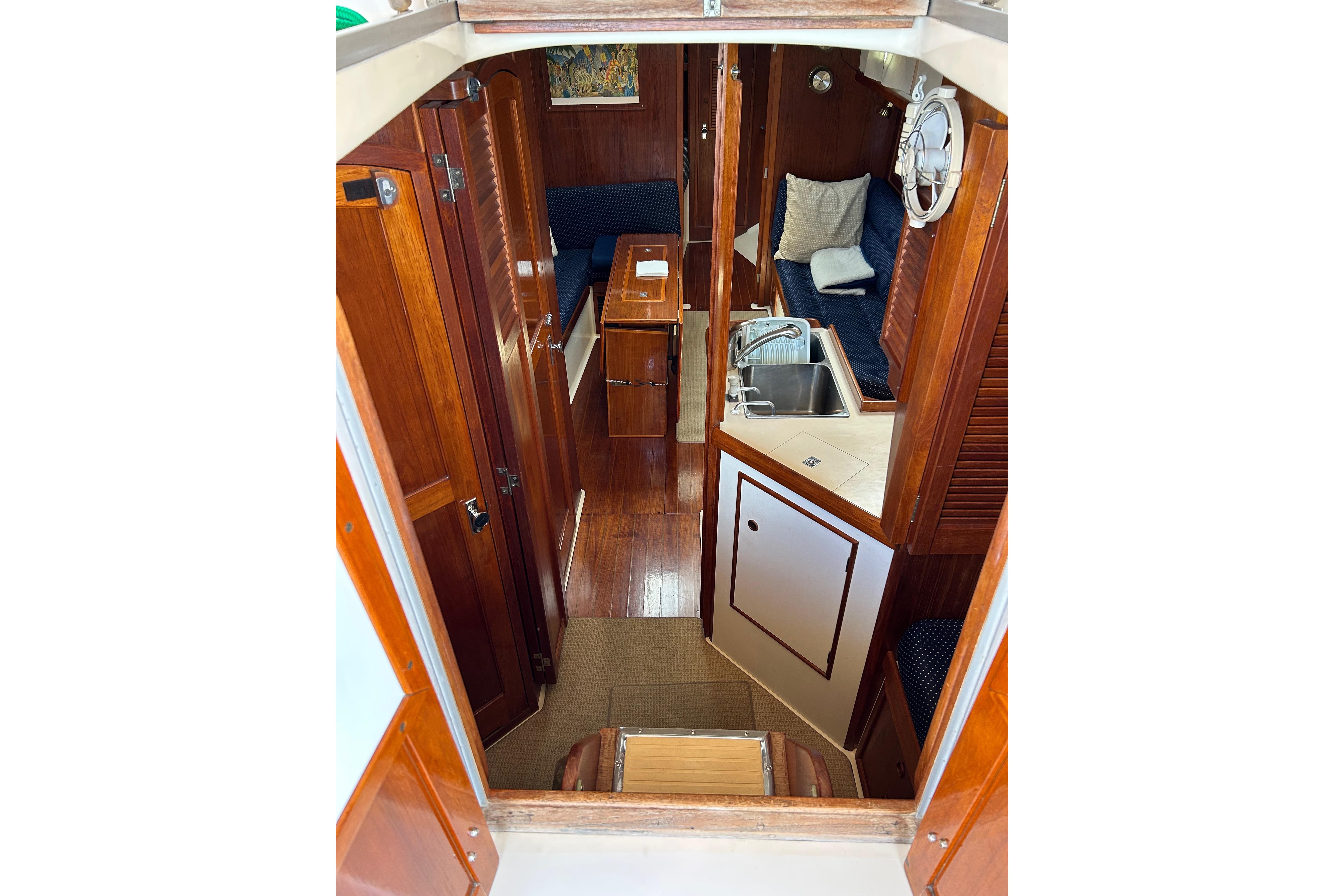 Interior of 1989 Hinterhoeller Nonsuch 36 sailboat with wood finish and compact kitchen.