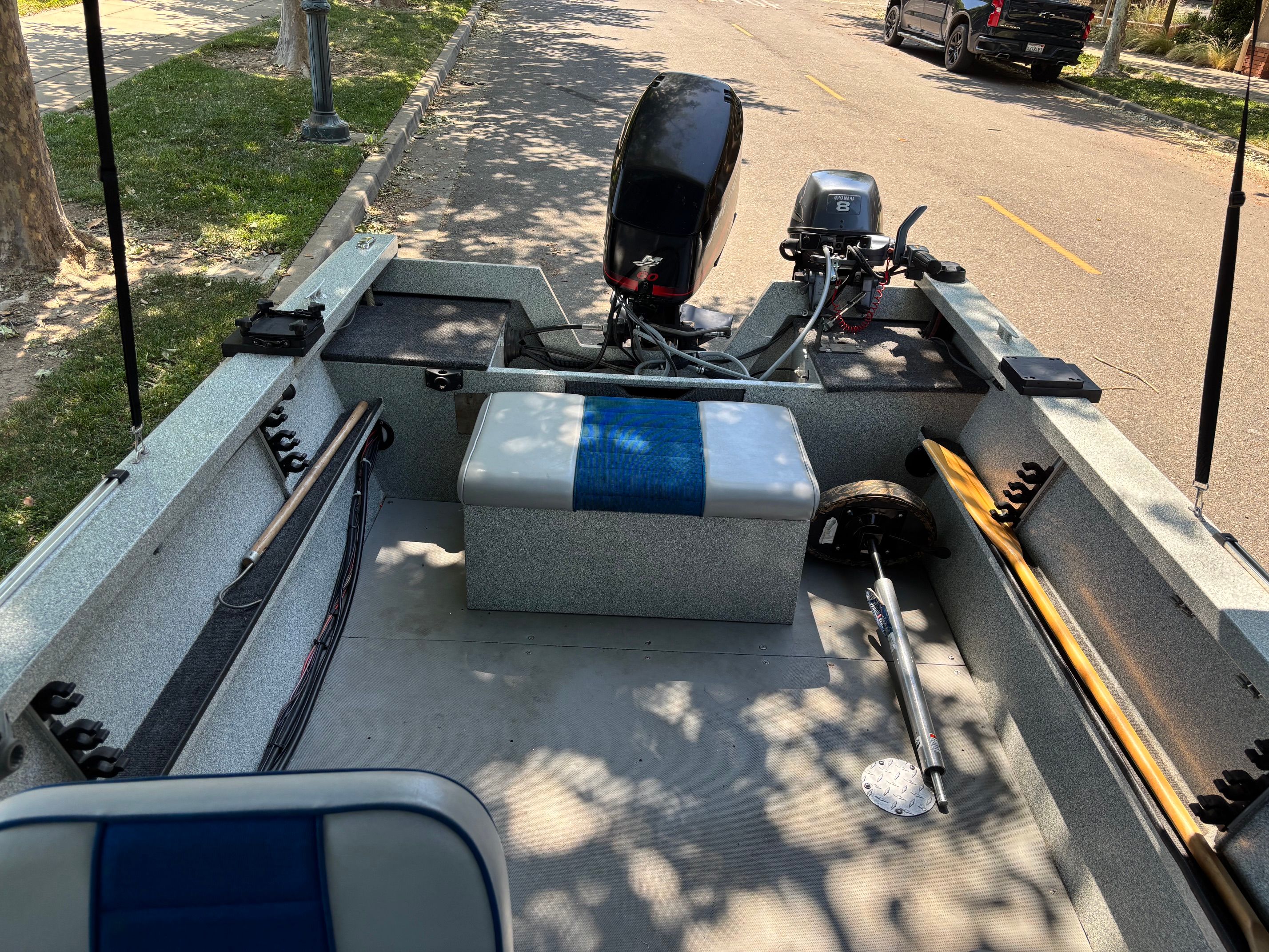 The image shows the interior of a 2002 Stryker Rogue boat parked on a street.