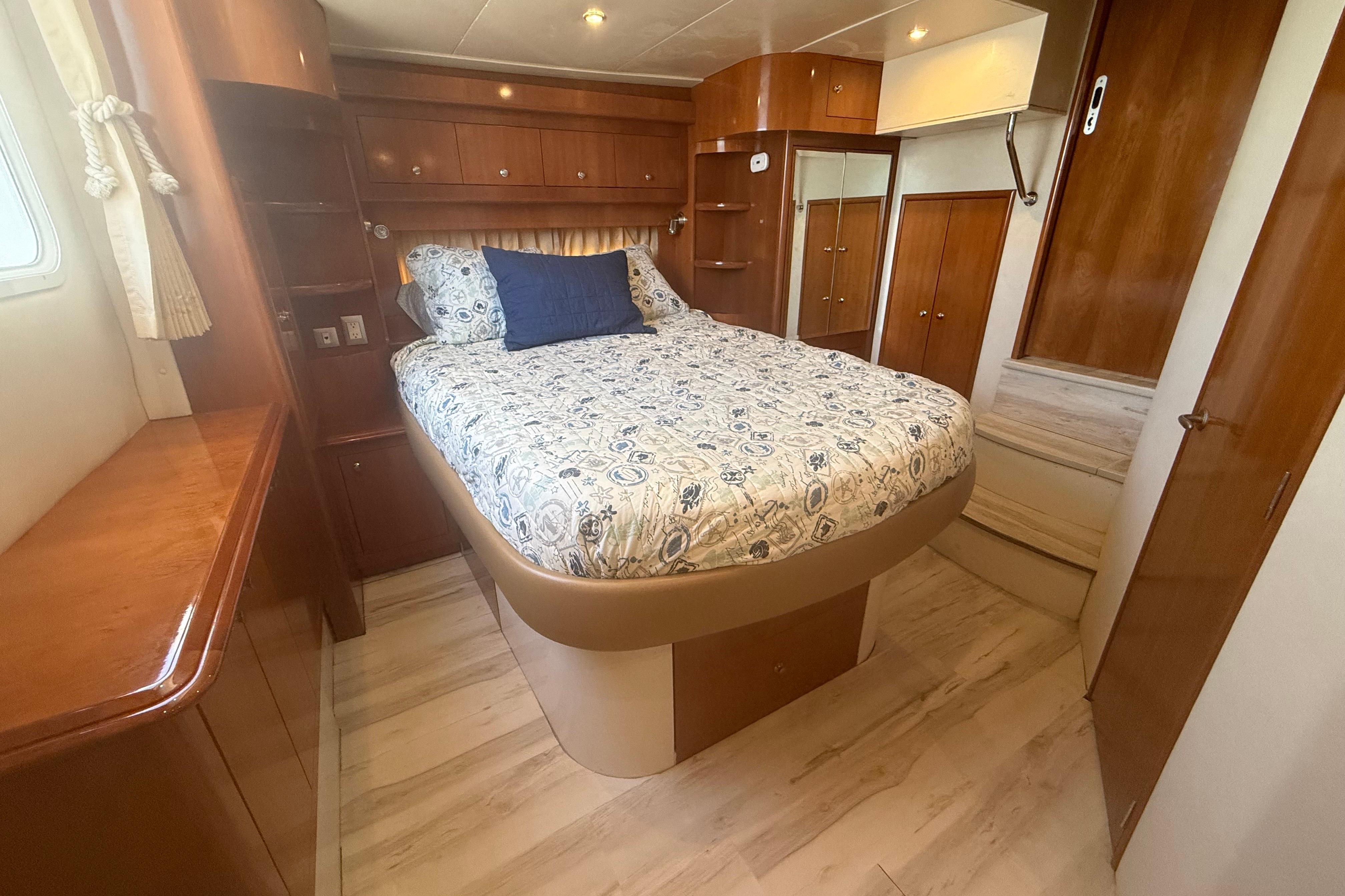 Luxurious bedroom interior of 2006 Carver 43 Motor Yacht with elegant wood finishes.
