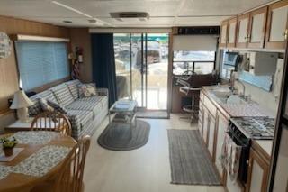 Interior of a 1994 PlayCraft 5215 houseboat with cozy living and kitchen area.