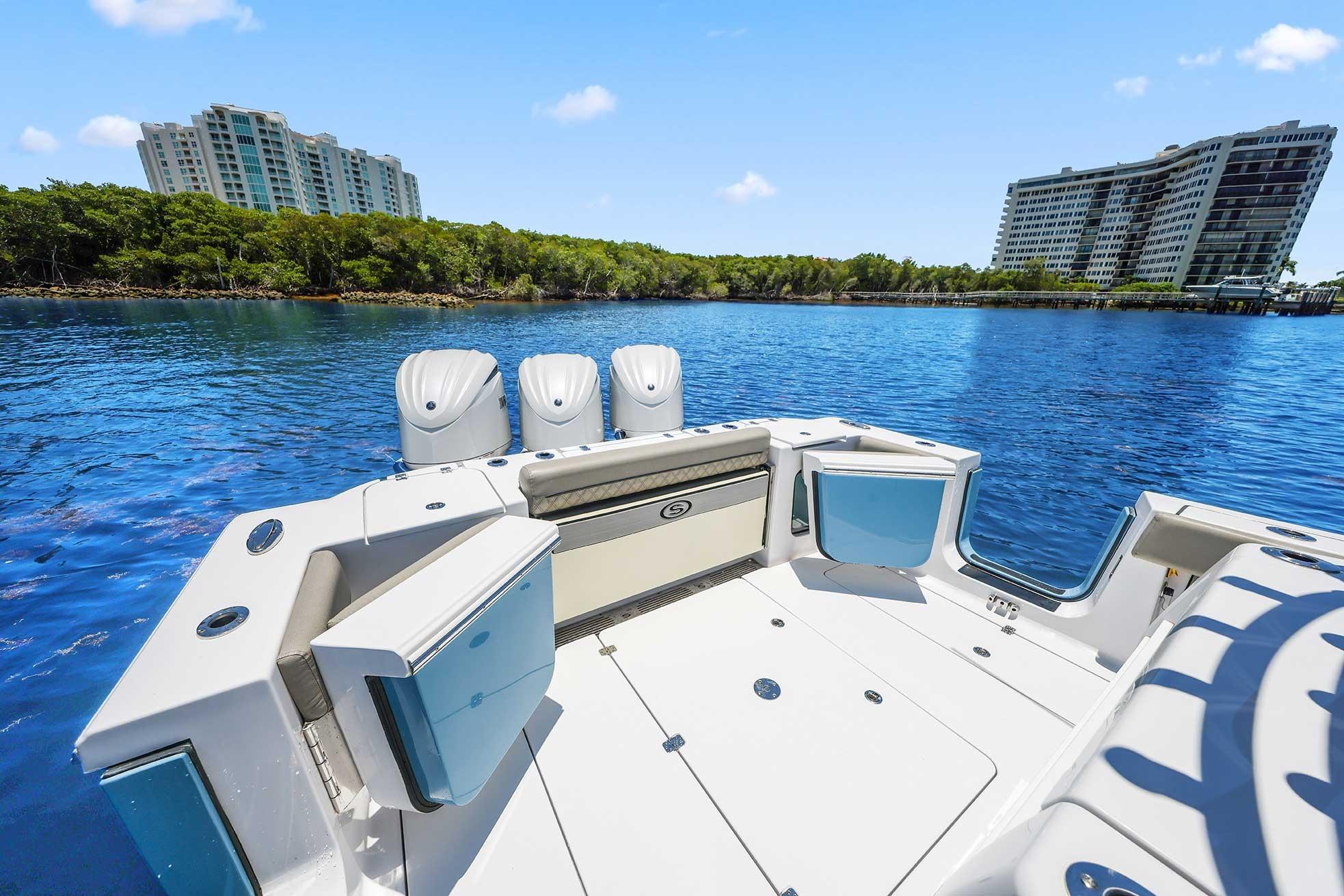 2024 Sportsman Open 352 Center Console boat on serene water with modern buildings in background.