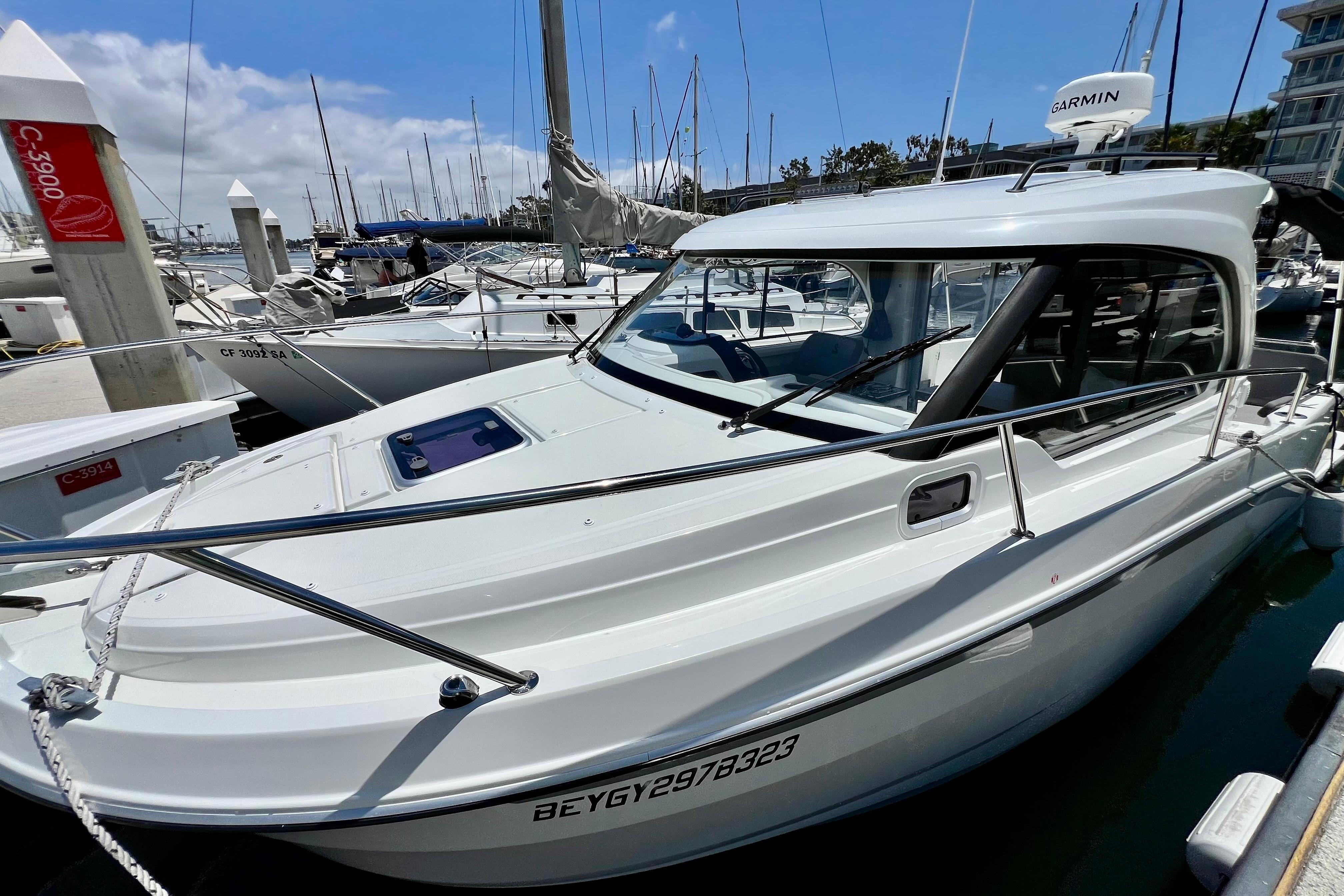 2023 Beneteau Antares 8 docked at marina, surrounded by other boats.