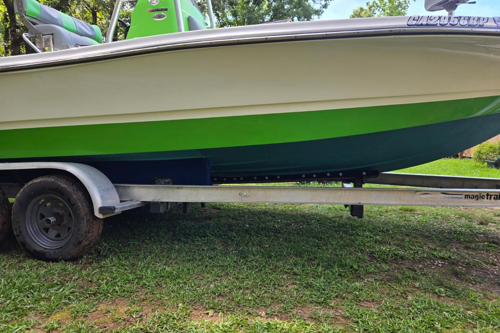 2016 Epic 21 Sport Console boat on trailer, green and white design, parked on grass.