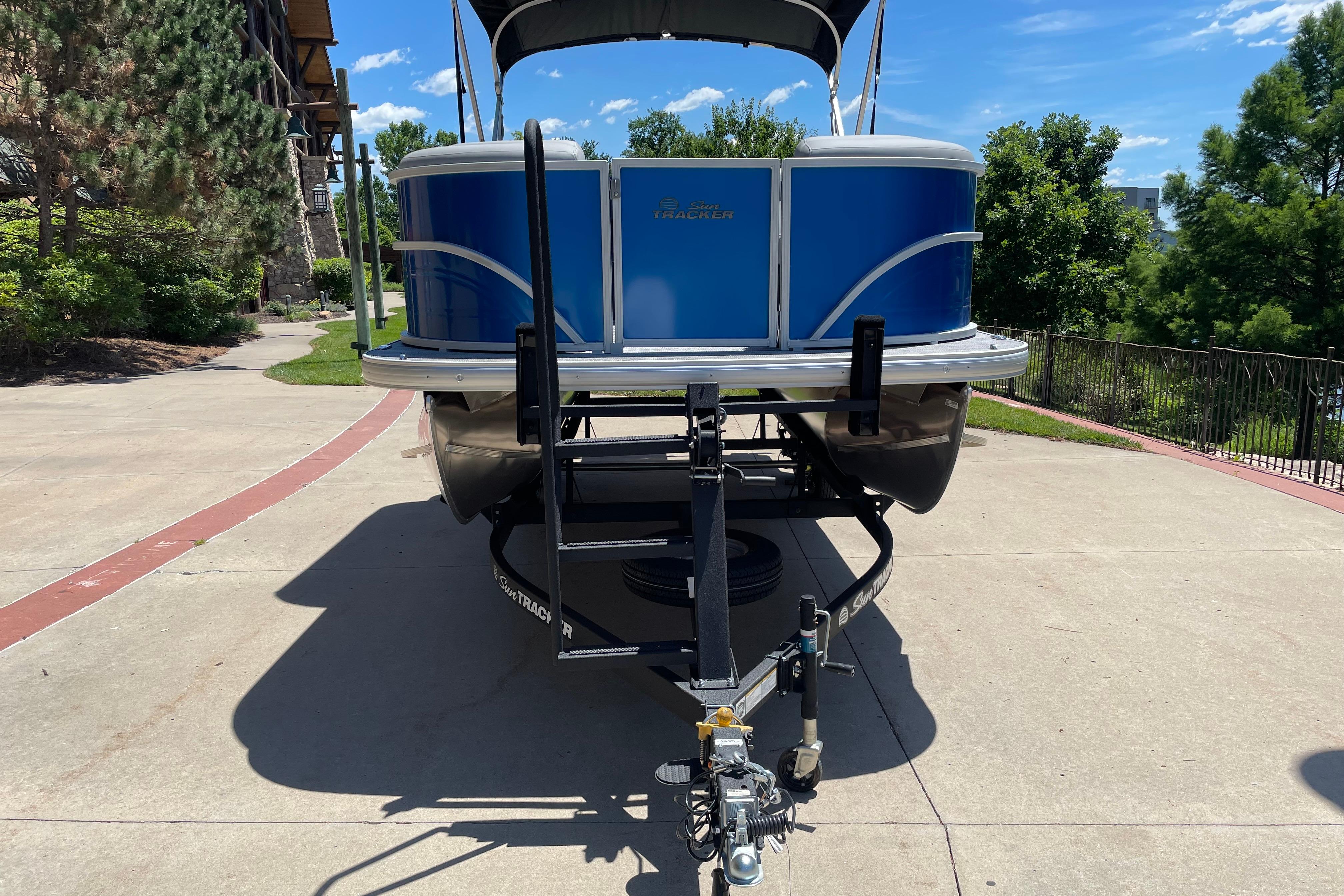 2026 Sun Tracker Party Barge 20 DLX pontoon boat on trailer, parked outdoors.
