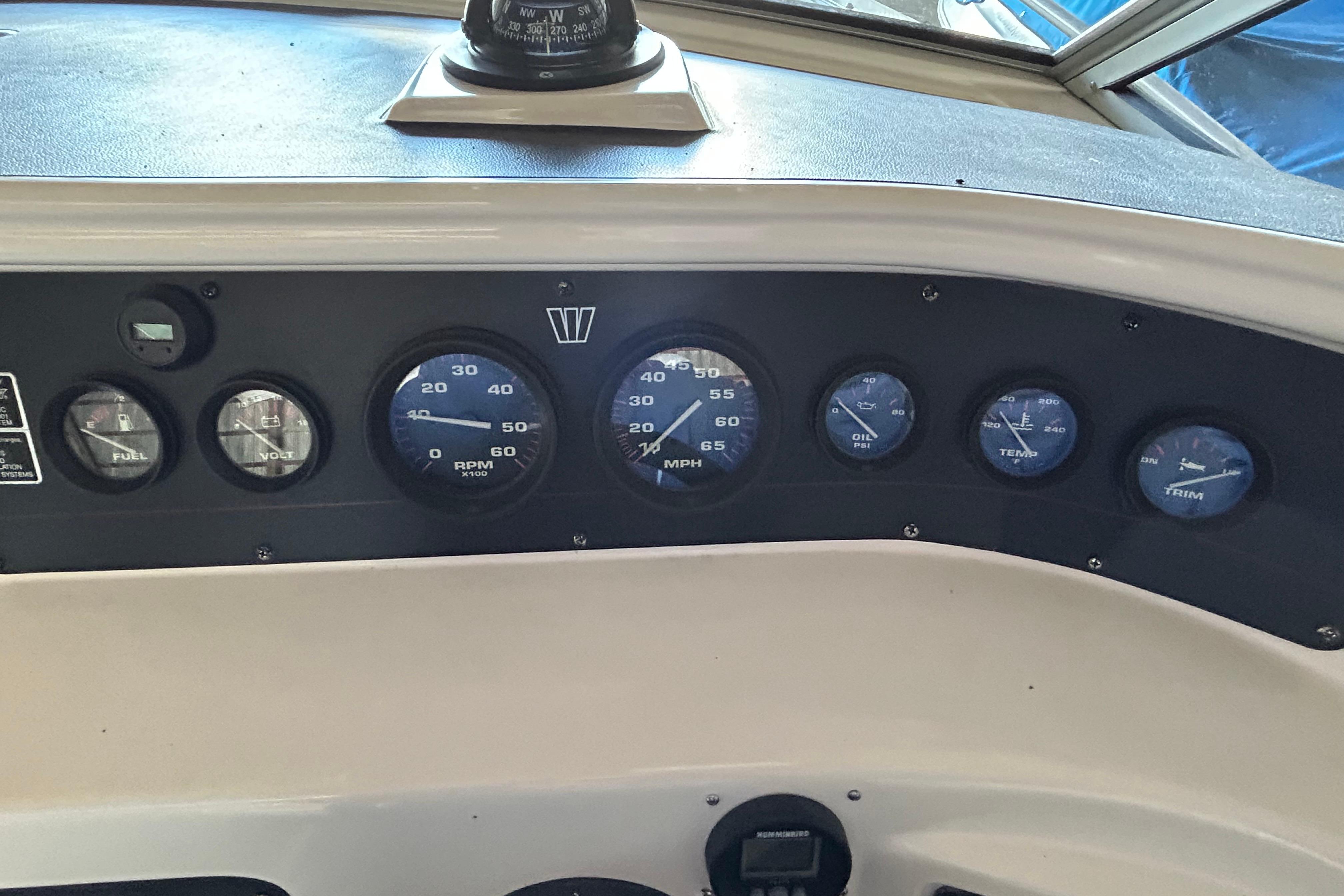 Dashboard of a 1991 Wellcraft 232 Eclipse boat with gauges and compass.