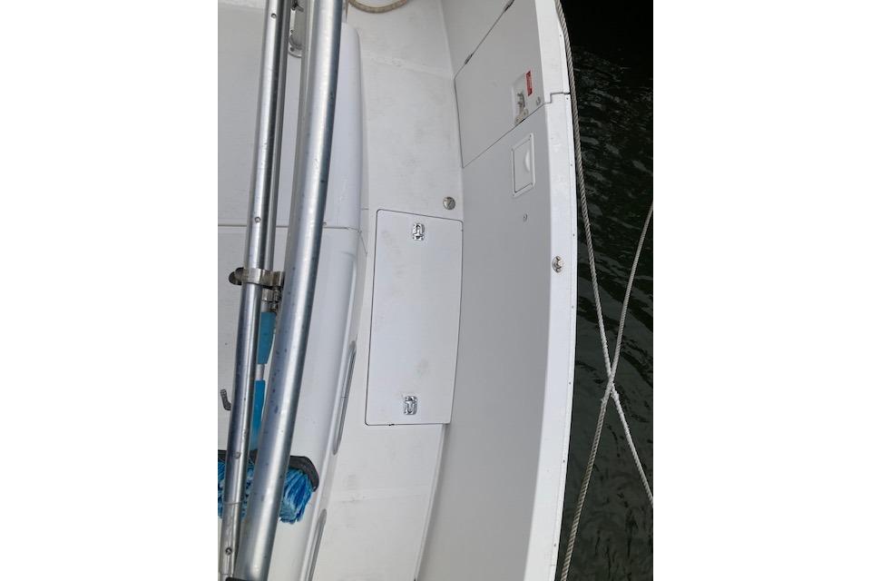 2000 Mainship 430 Trawler deck with storage compartments and railing, docked by water.