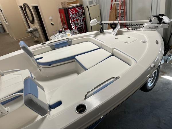 2025 Robalo 206 Cayman boat interior with white and blue seating in a garage setting.
