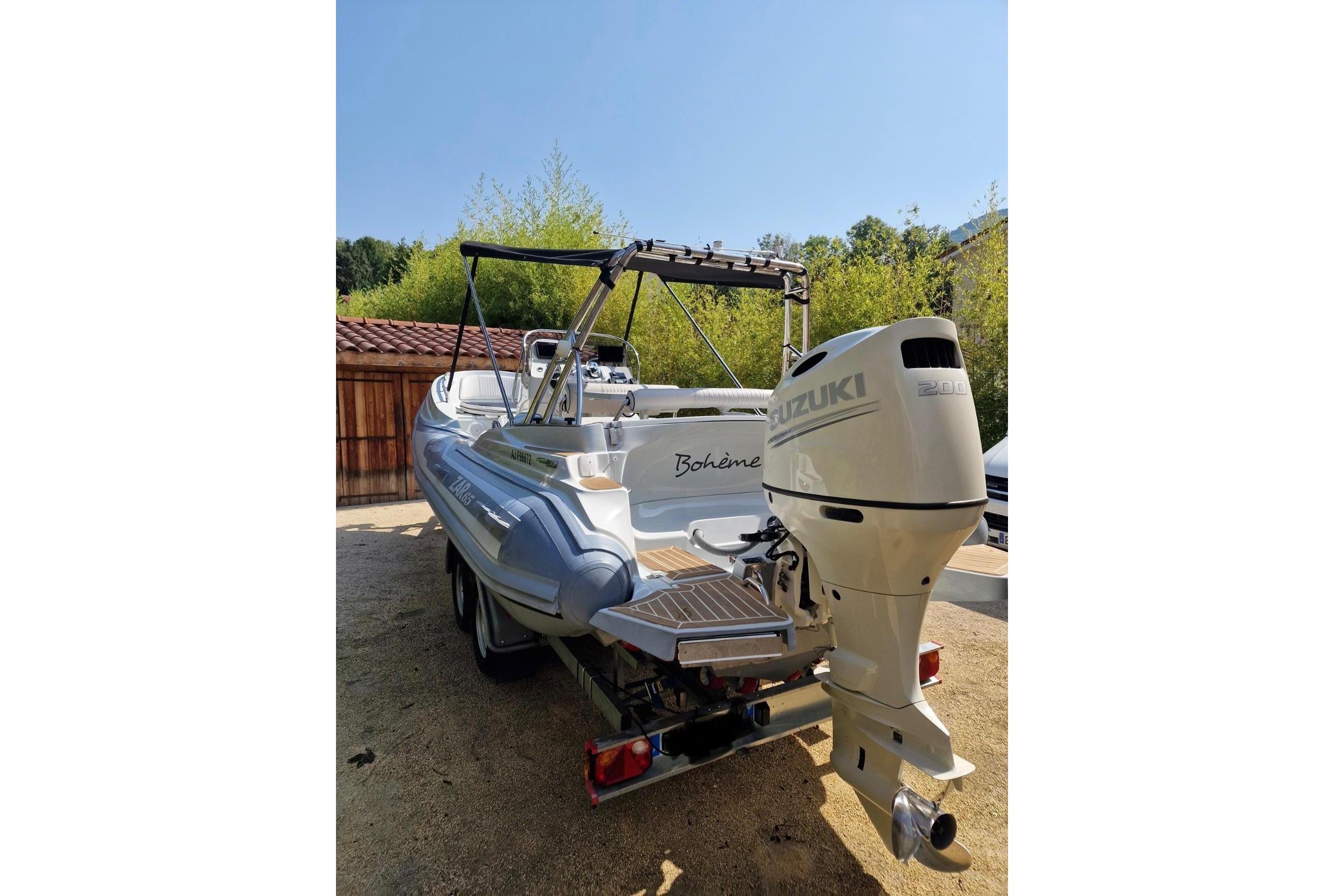 2019 Zar Formenti Zar 65 boat with Suzuki outboard motor in a sunny yard.