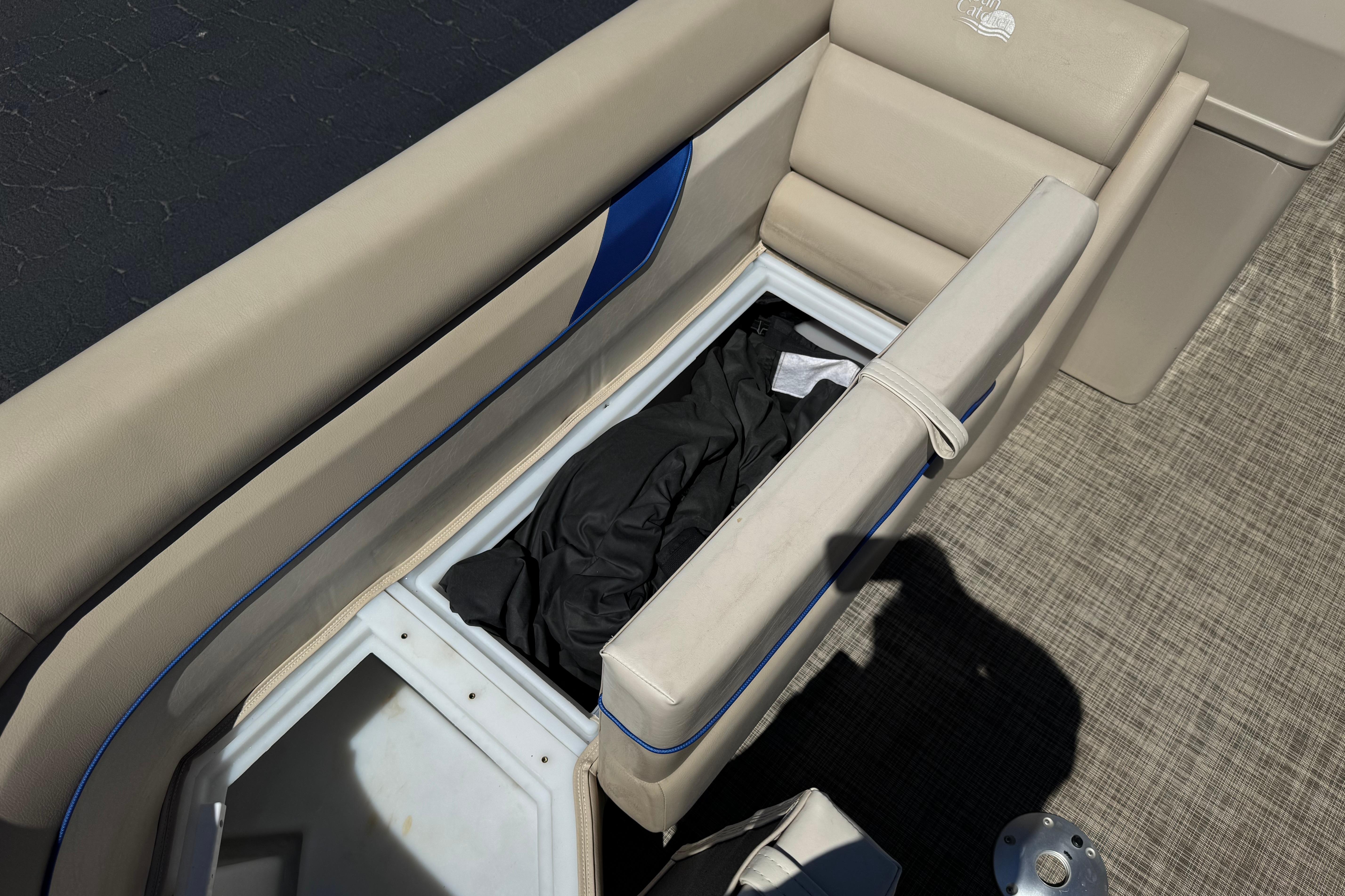 Open storage compartment on 2021 SunCatcher Select 20RCX boat with beige seating.