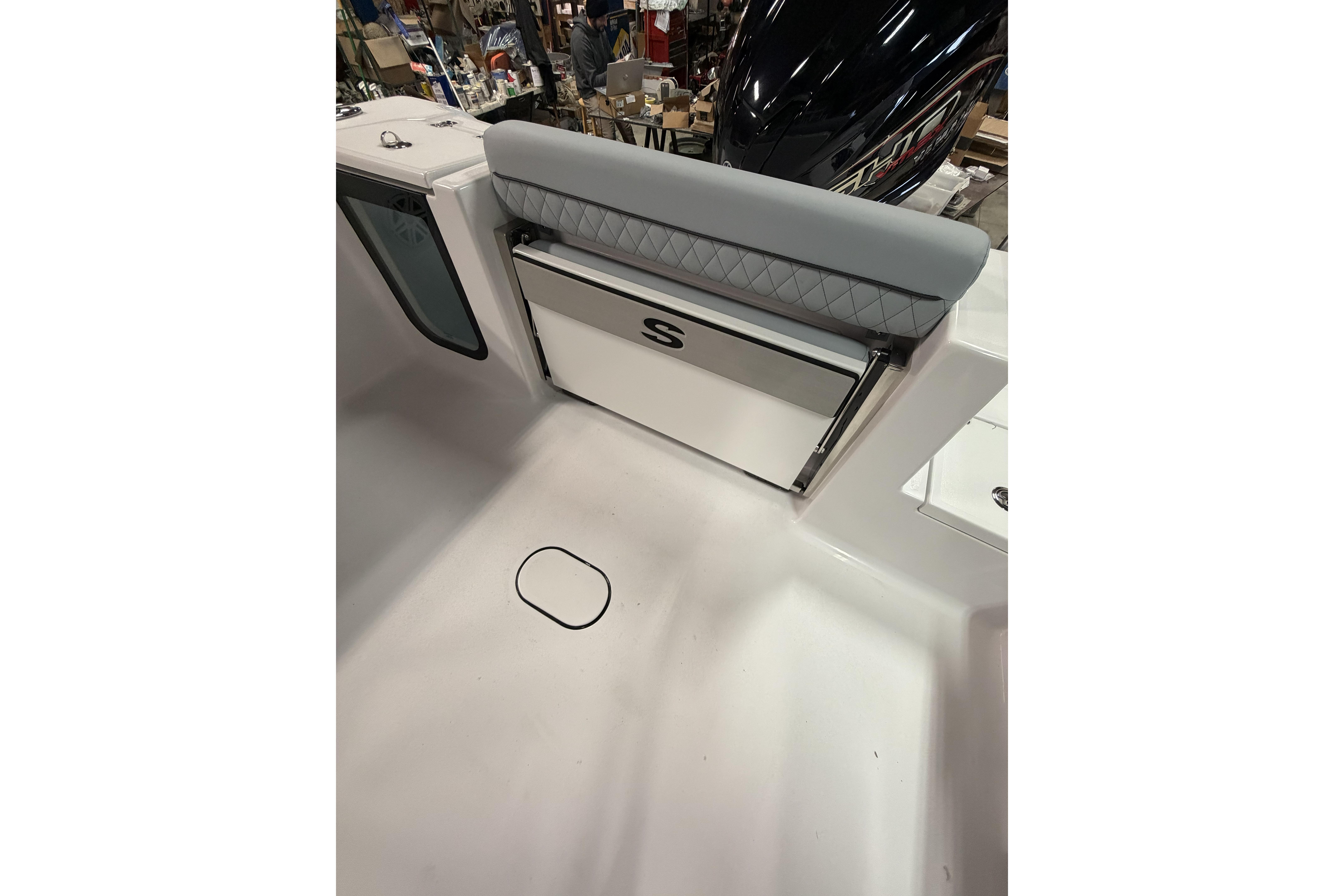 2026 Sportsman Open 232 Center Console boat interior with cushioned seating and storage.