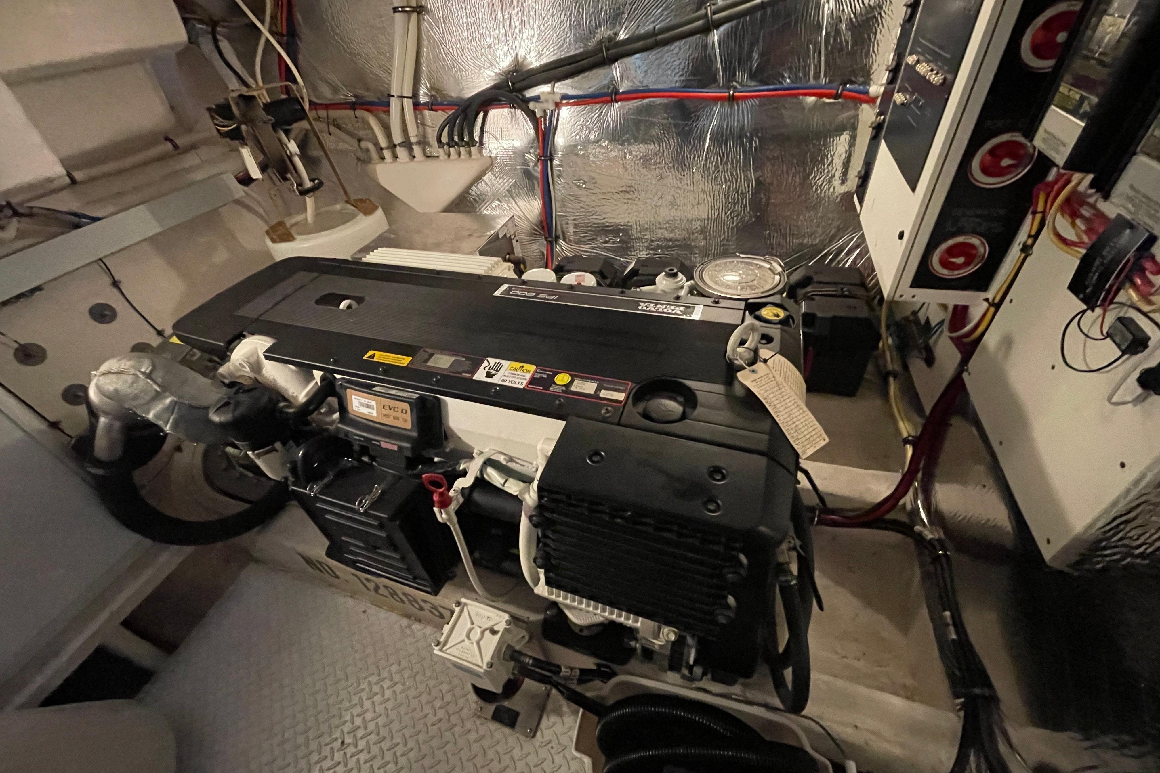 Engine room of 2012 Cruisers Yachts 48 Cantius, showcasing mechanical components and wiring.