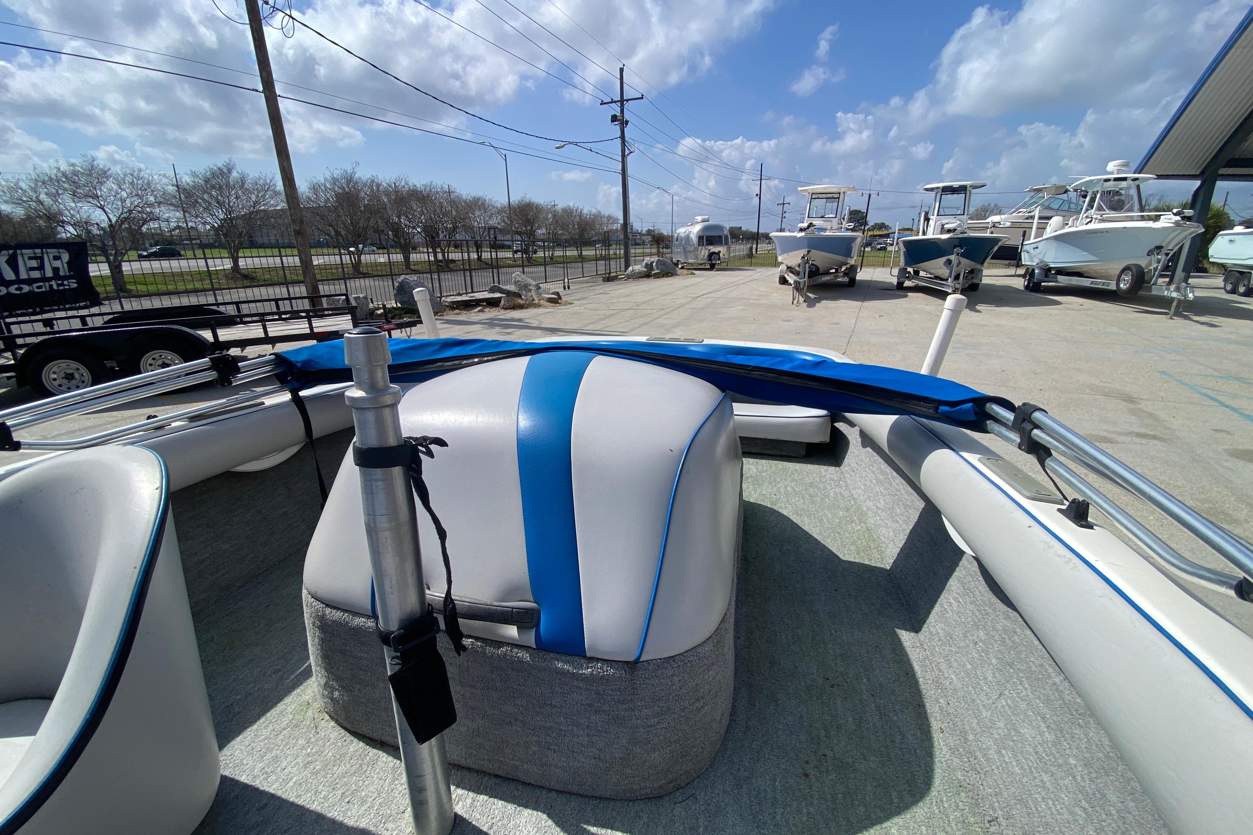 1997 Malibu Tantrum boat interior with blue and white seating, parked outdoors under a cloudy sky.