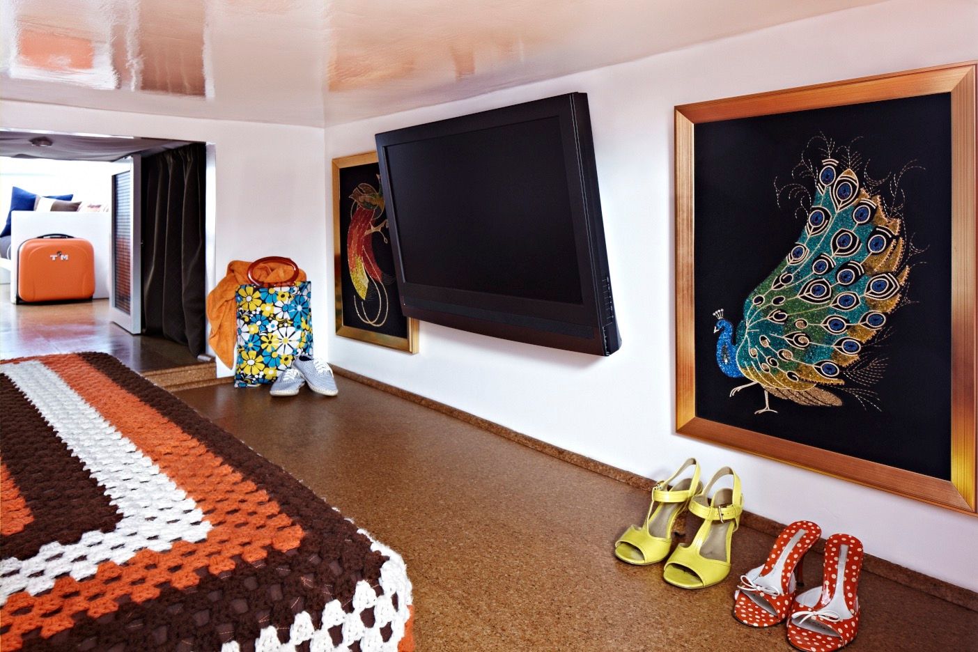 Interior of a houseboat with a TV, colorful shoes, and decorative wall art.