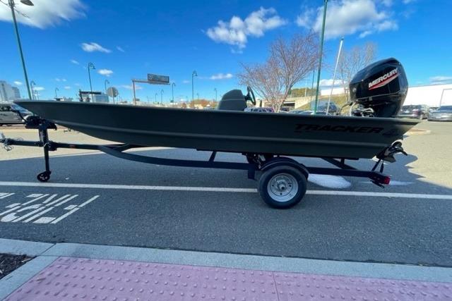 2026 Tracker Grizzly 1648 SC boat on trailer, parked outdoors under blue sky.