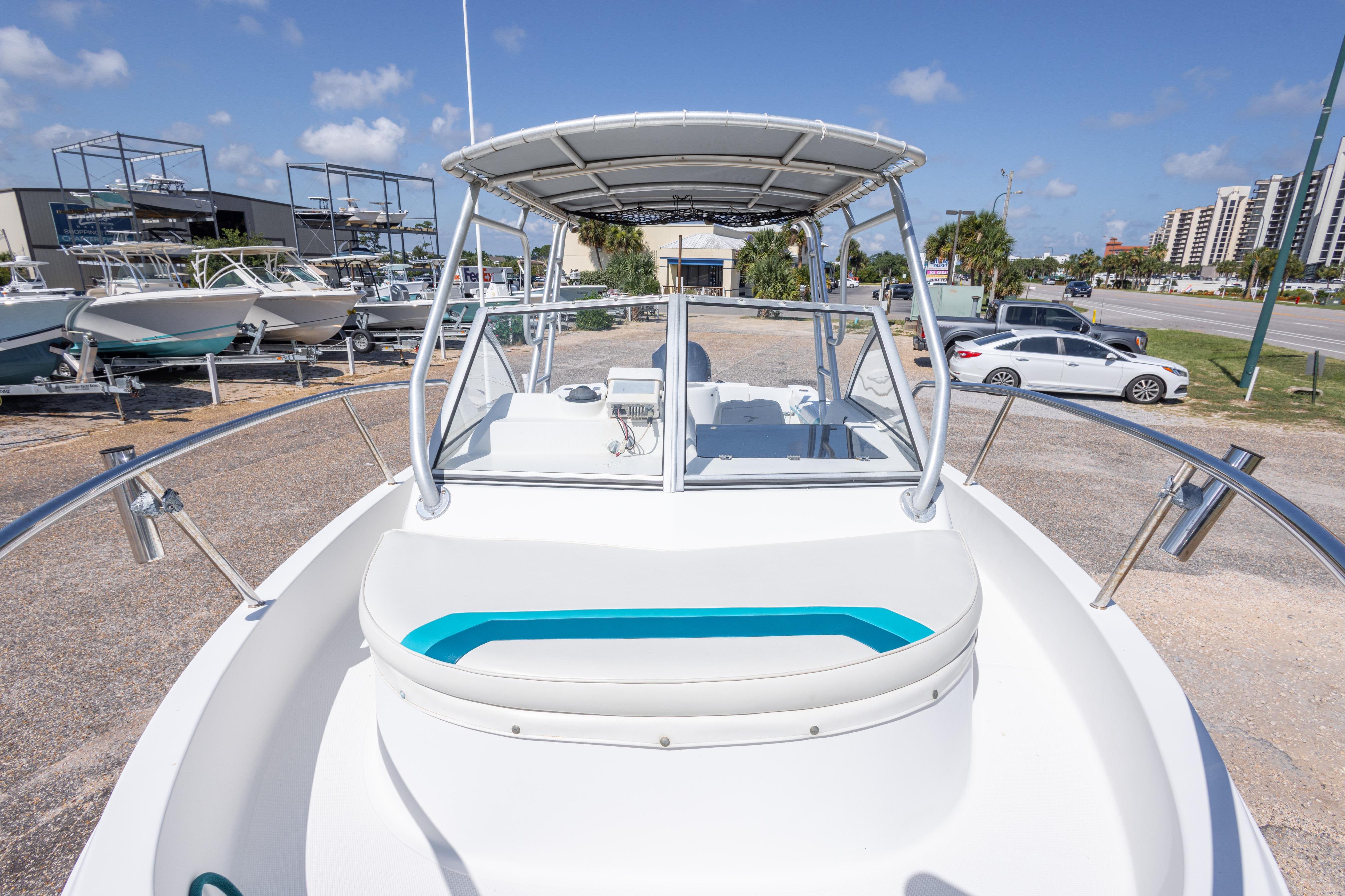 1999 Aquasport 225 Explorer boat on display in a sunny outdoor setting.