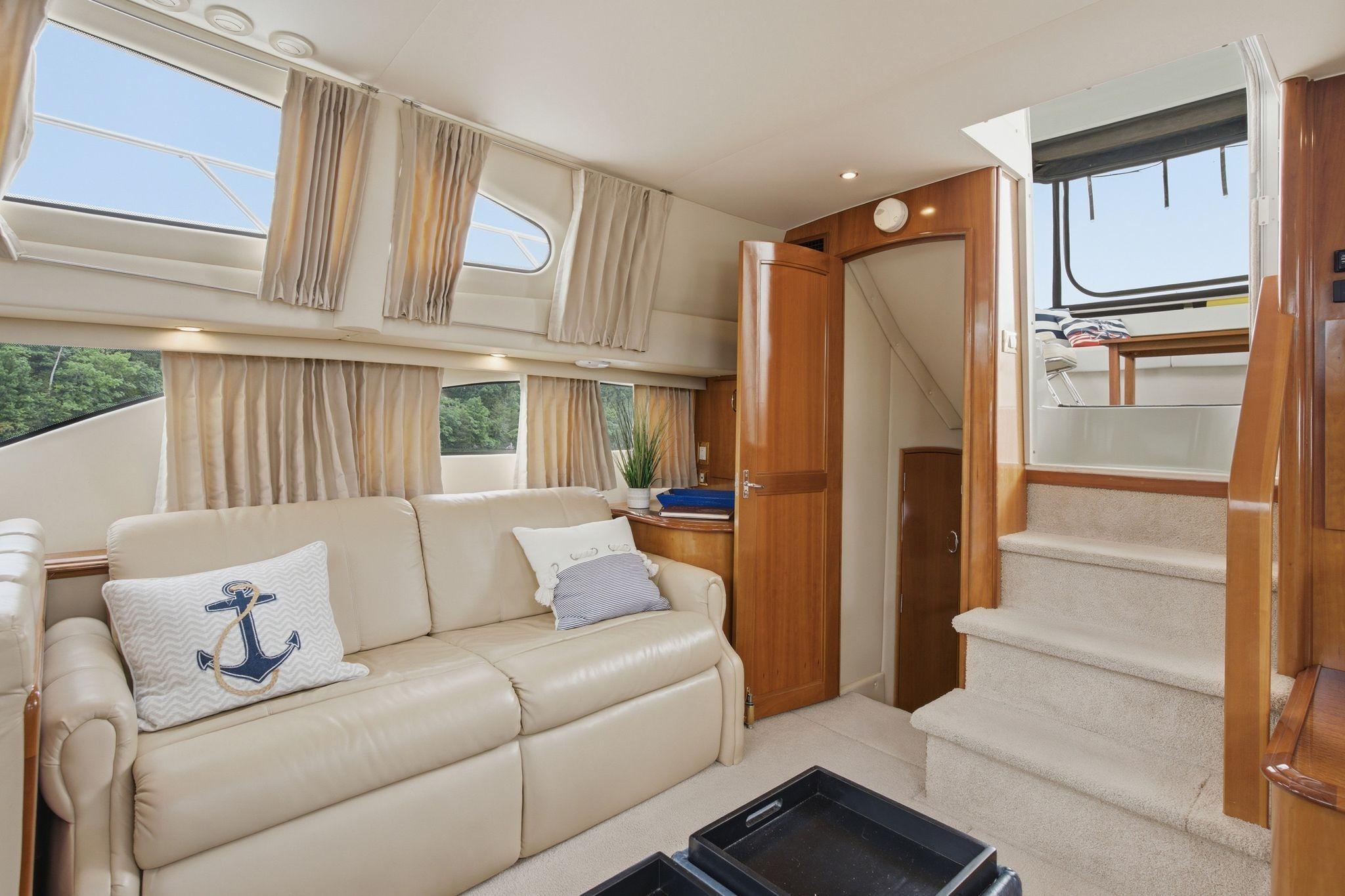 Interior of 2005 Carver 39 Motor Yacht with beige sofa and nautical decor.