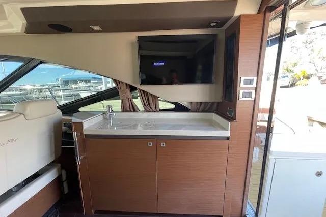 Luxurious interior of 2016 Sea Ray Sundancer 510 yacht with modern kitchenette and TV.