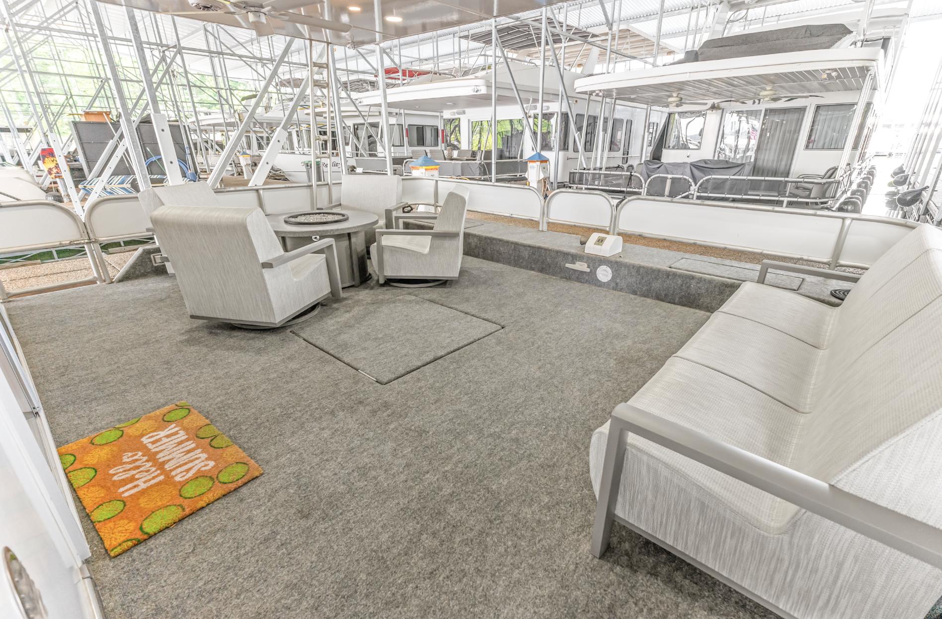 Spacious deck of 1997 Sumerset 18 x 93 houseboat with seating and table.
