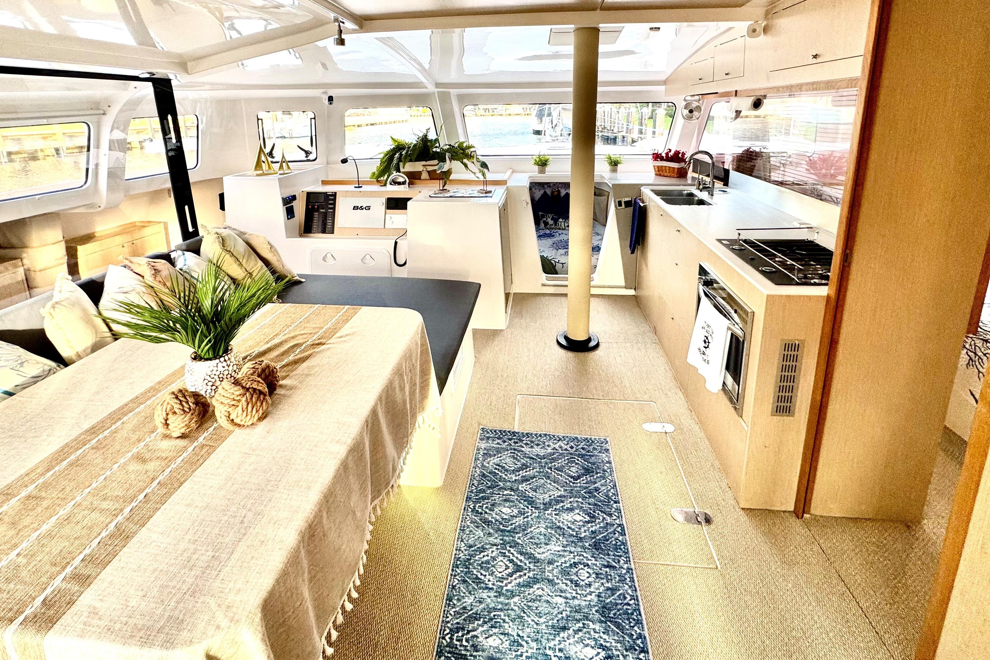 Modern NEEL 43 interior with dining area, kitchen, and nautical decor, 2023 model.