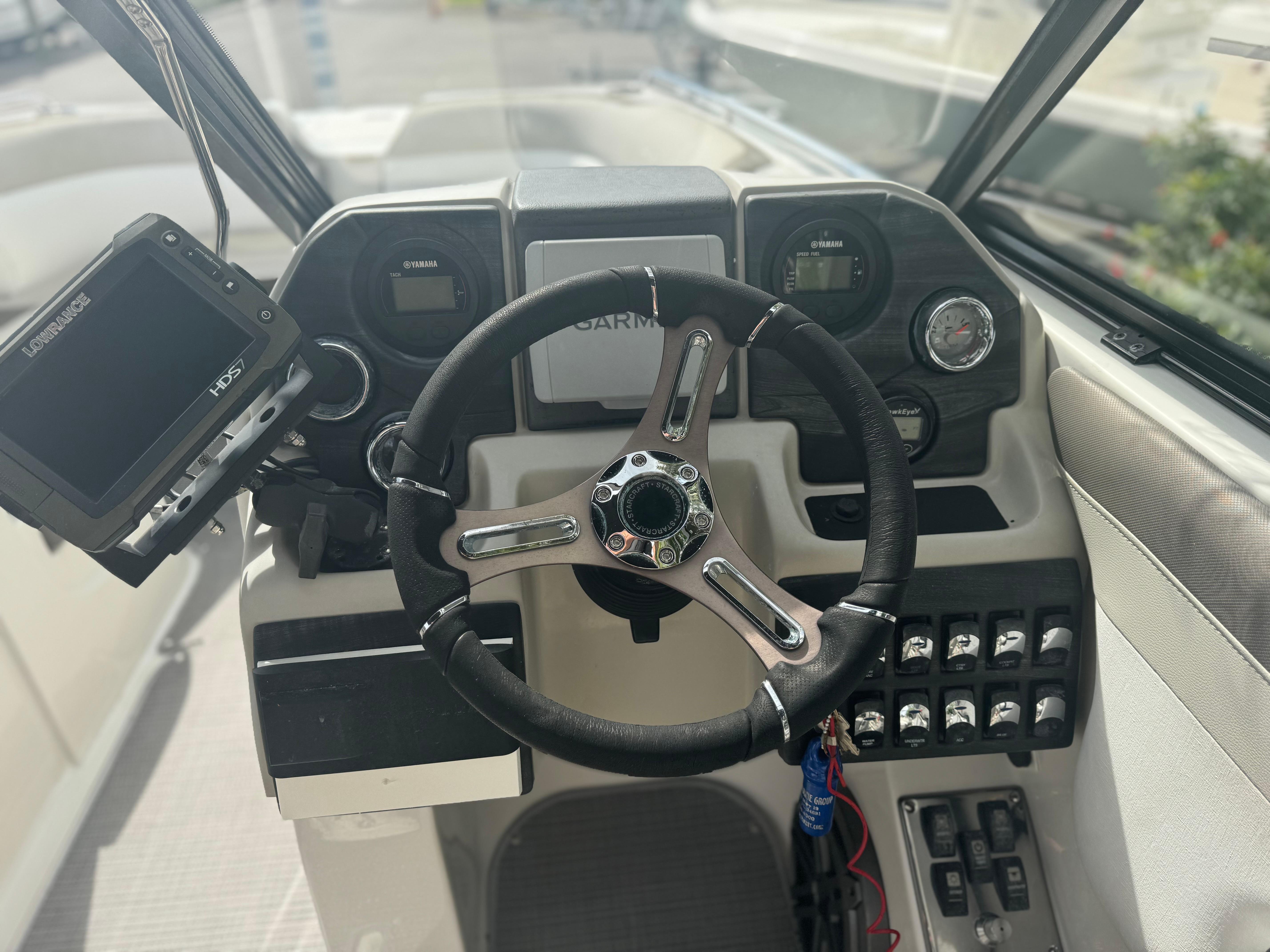2017 Starcraft 230 OB SCX EXT boat dashboard with steering wheel and navigation controls.