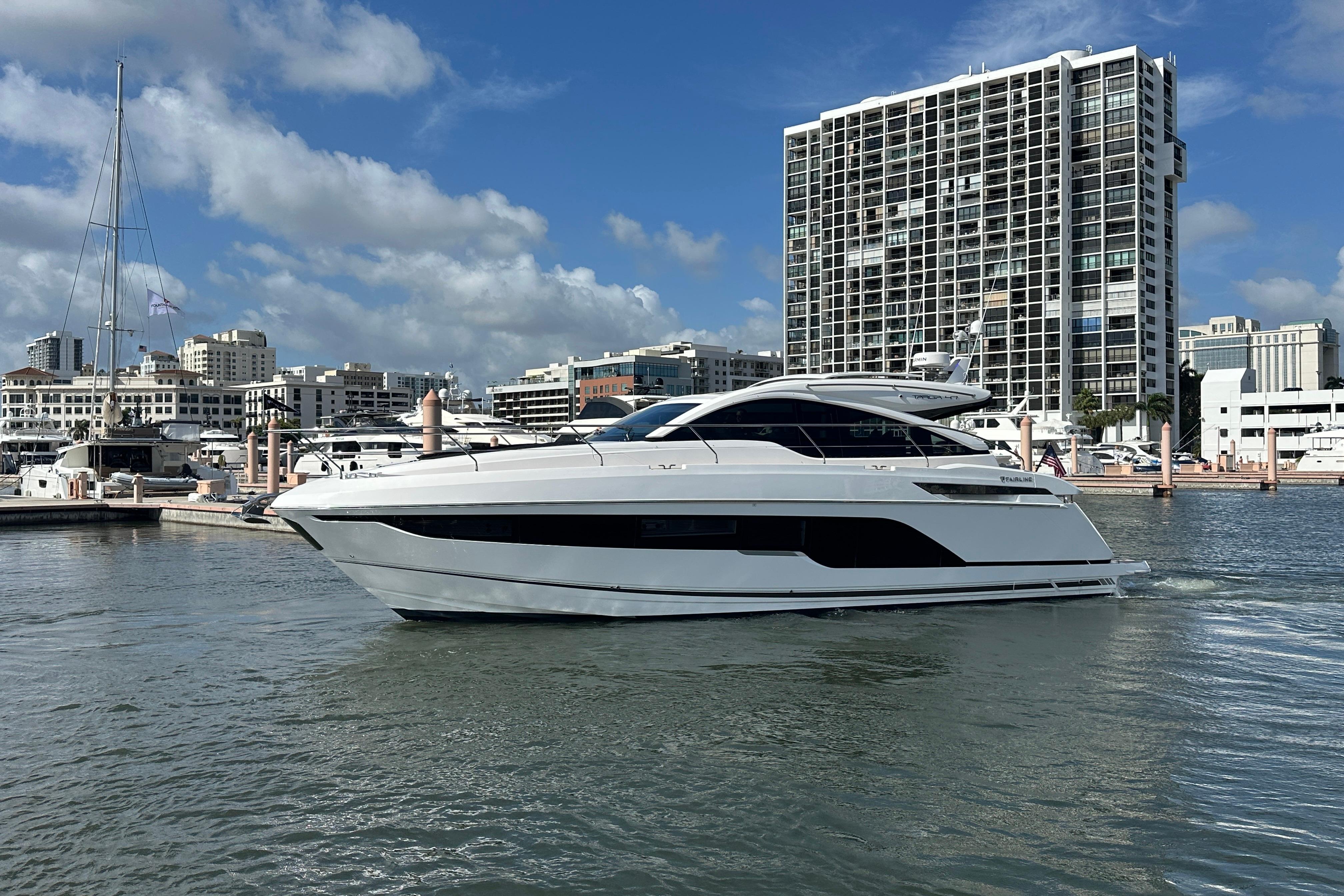 2026 Fairline Targa 47 GT yacht docked in urban marina with cityscape backdrop.