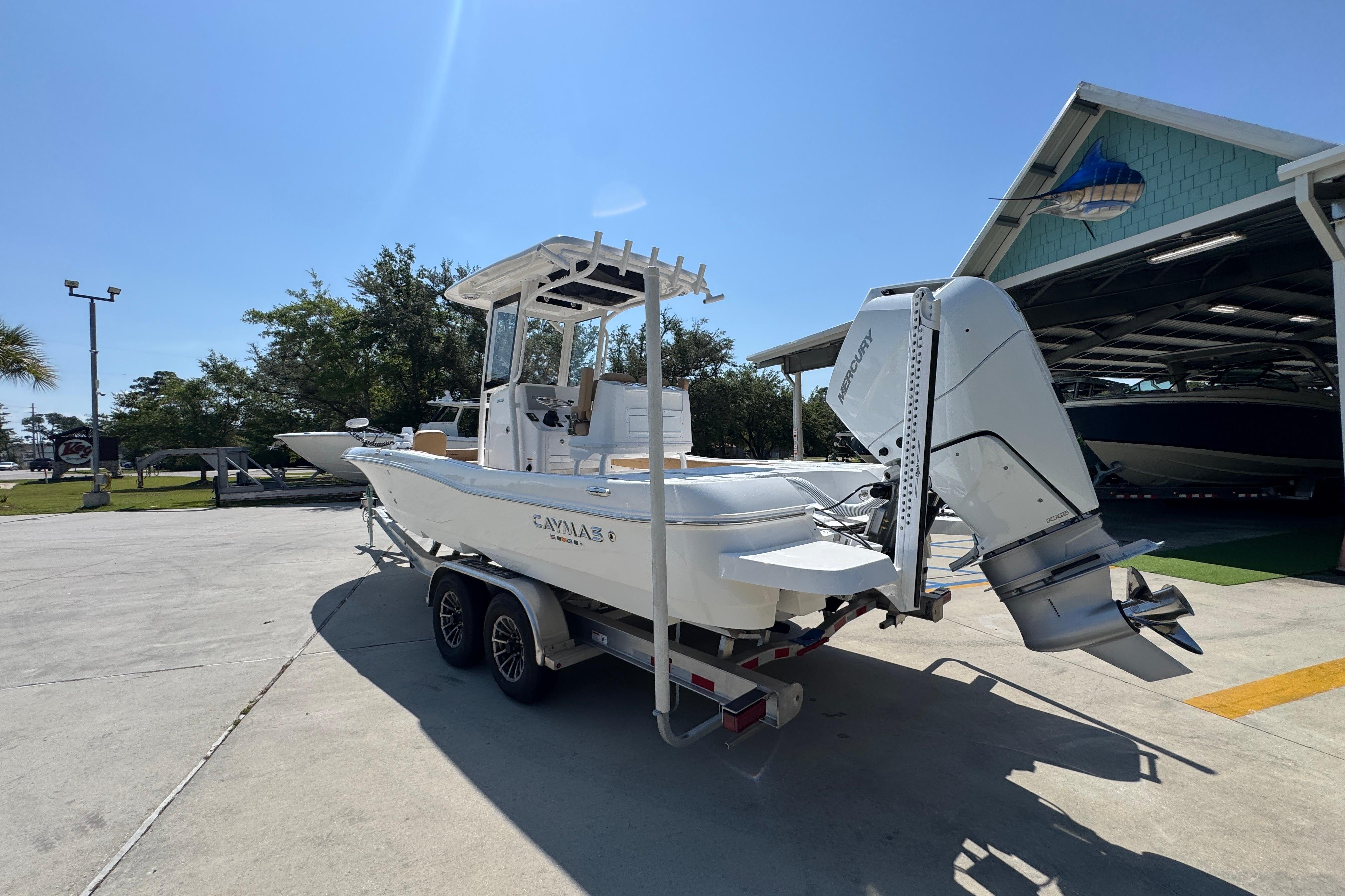 2027 Caymas 26 HB boat on trailer, parked outdoors under clear sky.