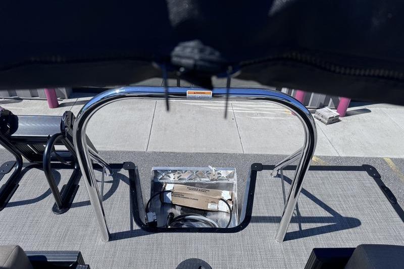 2027 Manitou Aurora 23 RF SHP boat interior with metal railing and storage compartment.
