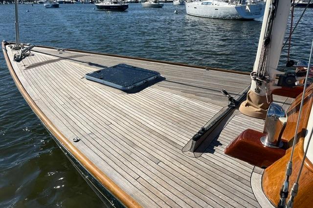 Sleek 2006 Morris 36 sailboat with wooden deck, docked on calm waters.
