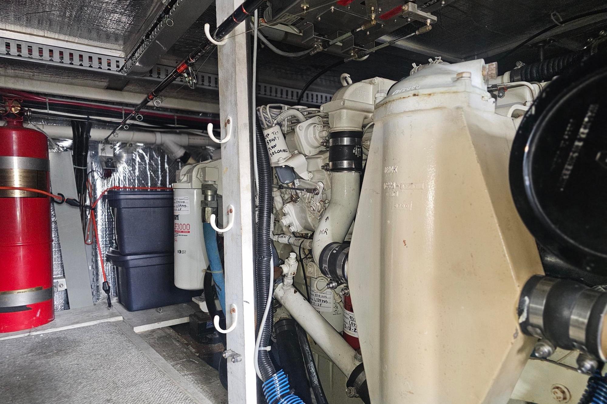 Engine room of 2002 Carver 450 Voyager Pilothouse with mechanical components and fire extinguisher.