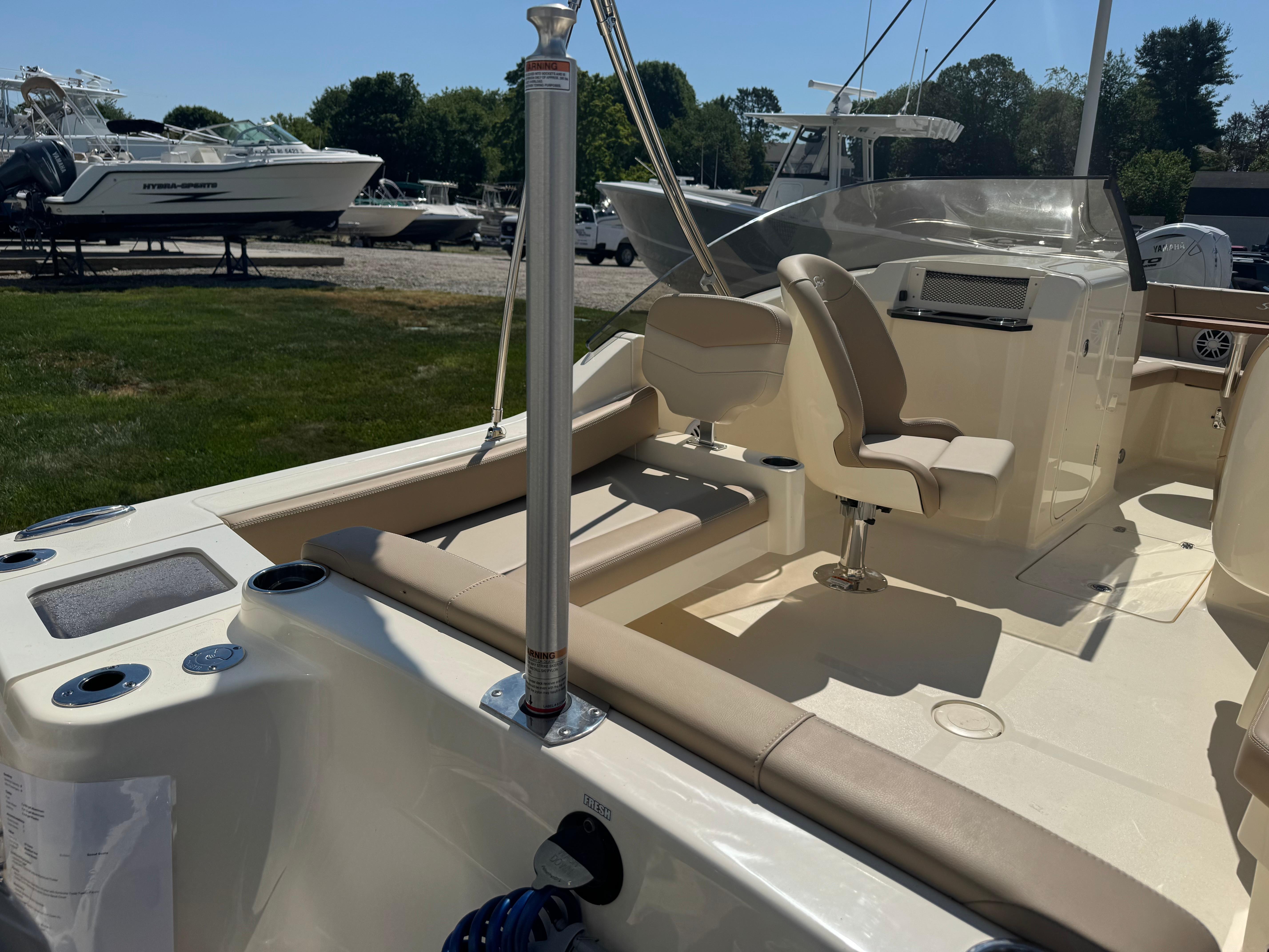 2025 Scout 215 Dorado boat interior with seating and steering area, parked outdoors.