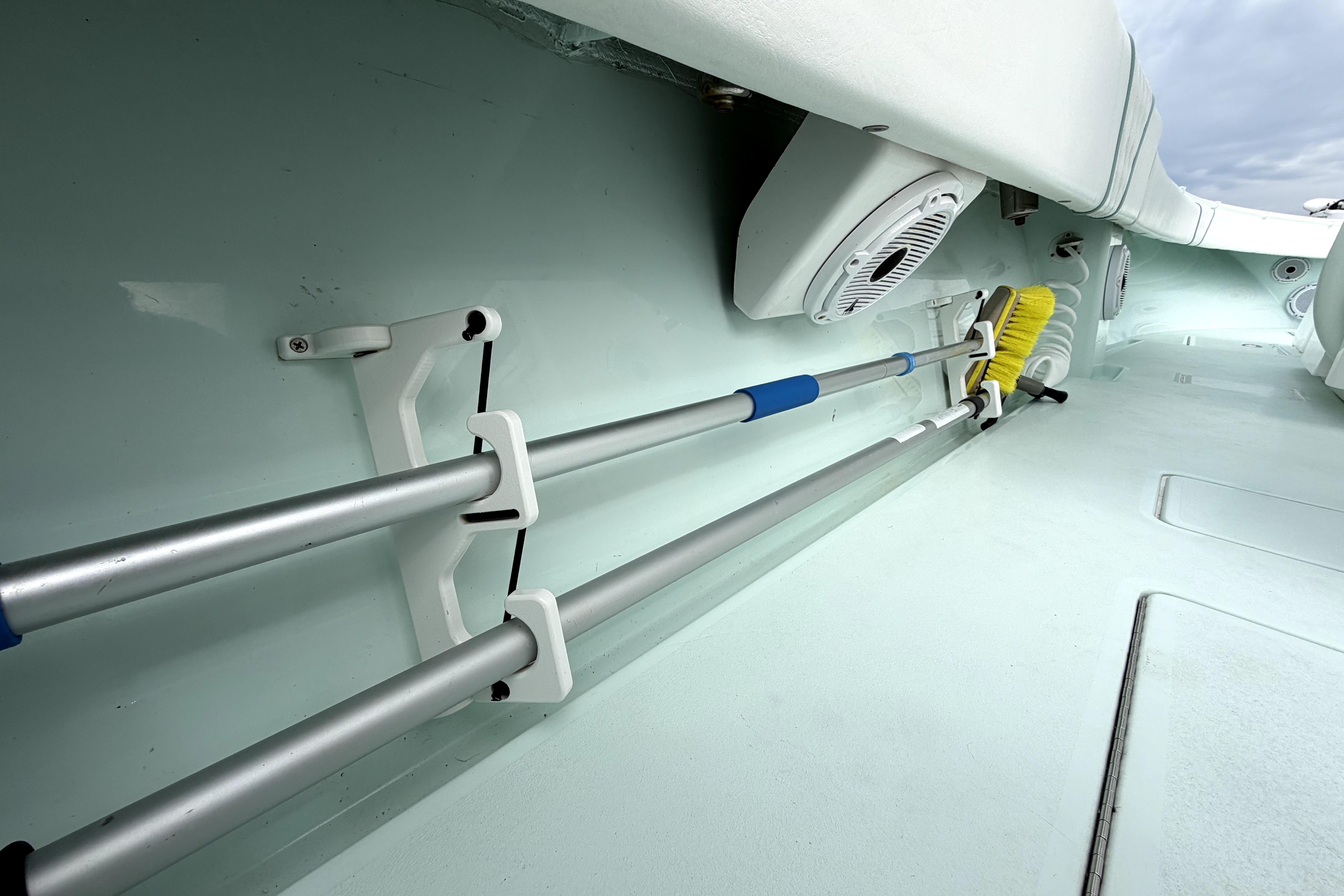 2019 Contender 30 ST boat interior with mounted cleaning tools and speakers.