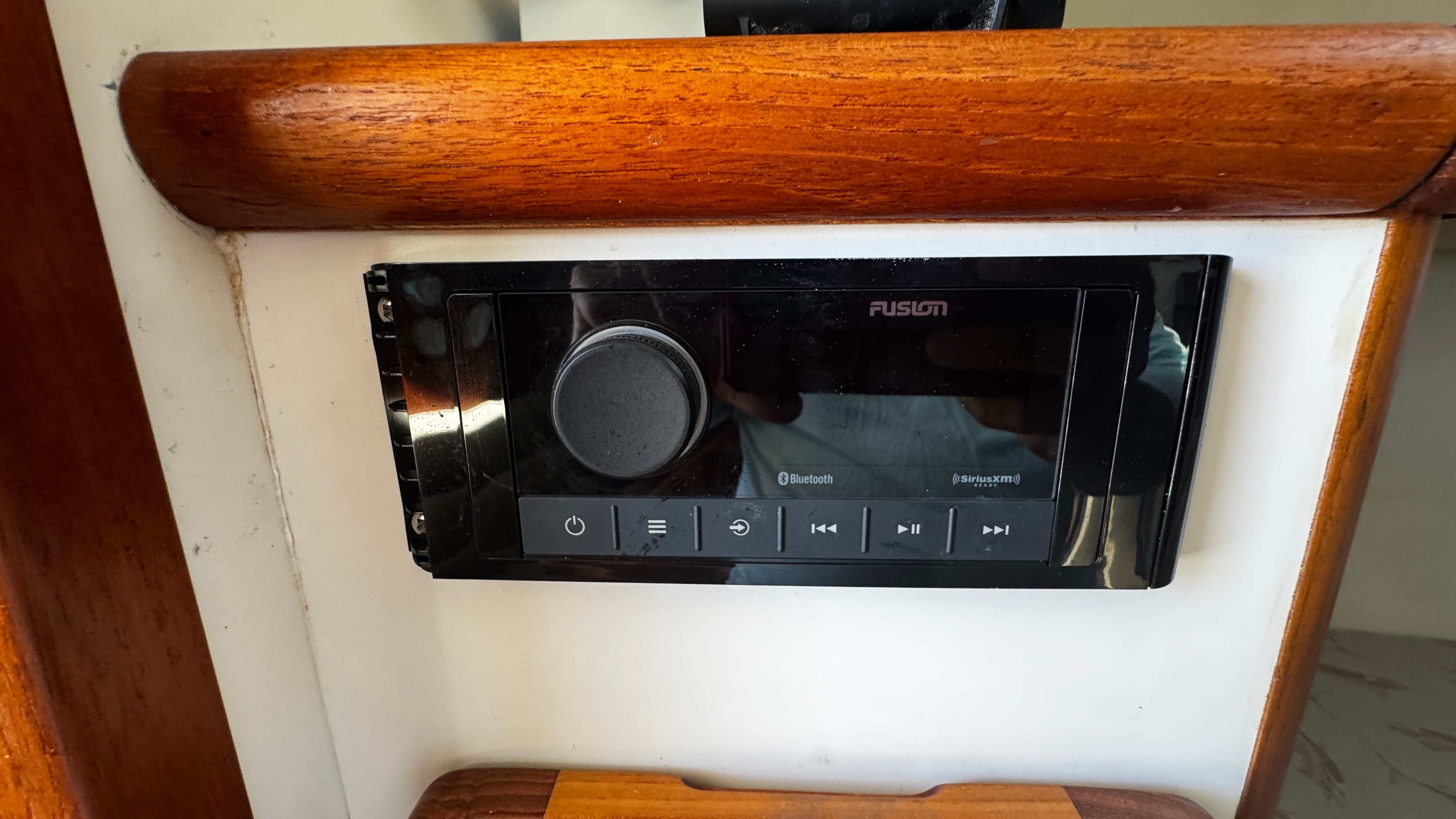 A Fusion audio system is installed in a wooden panel.