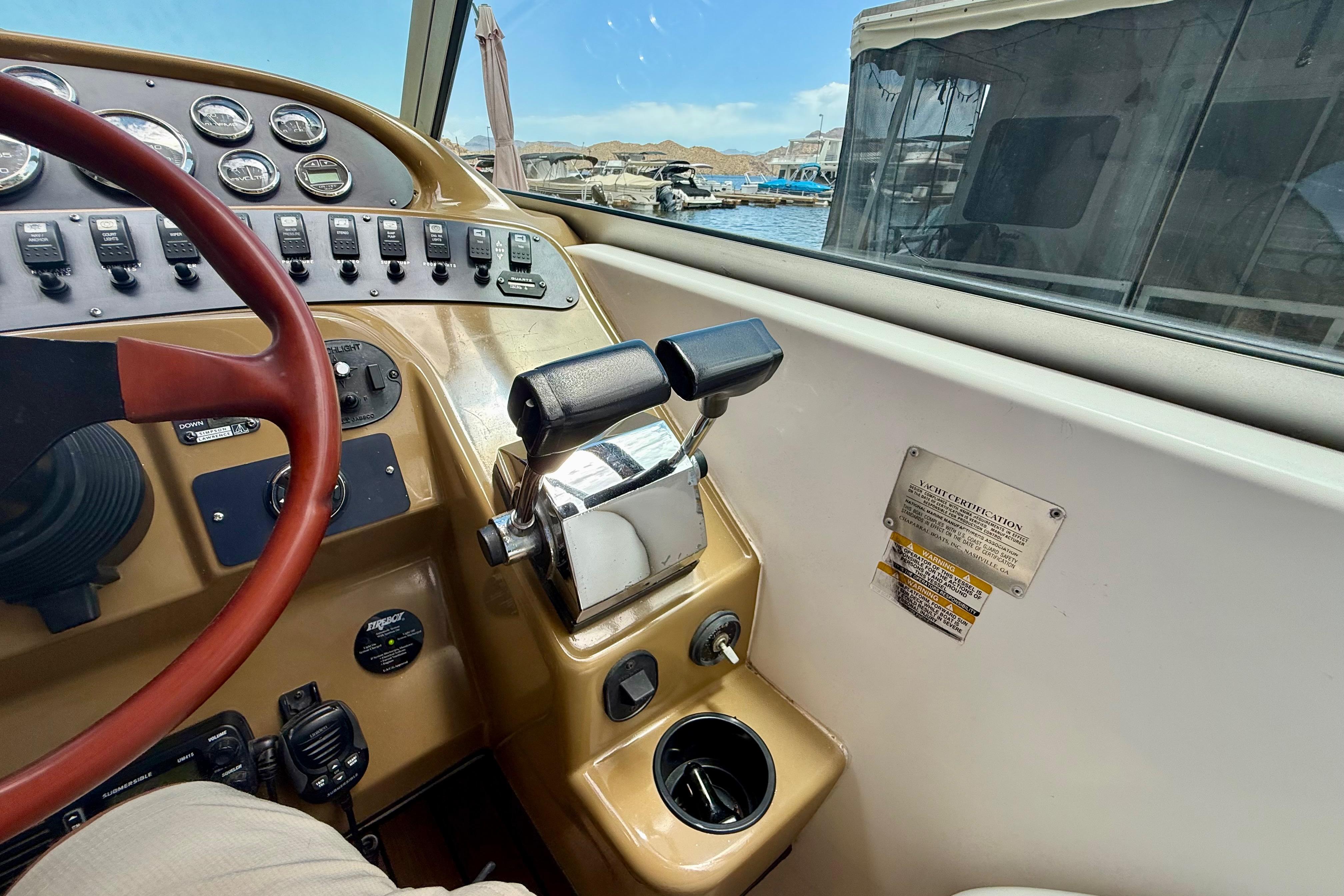 1999 Chaparral Signature 300 helm with controls and gauges, docked at marina.