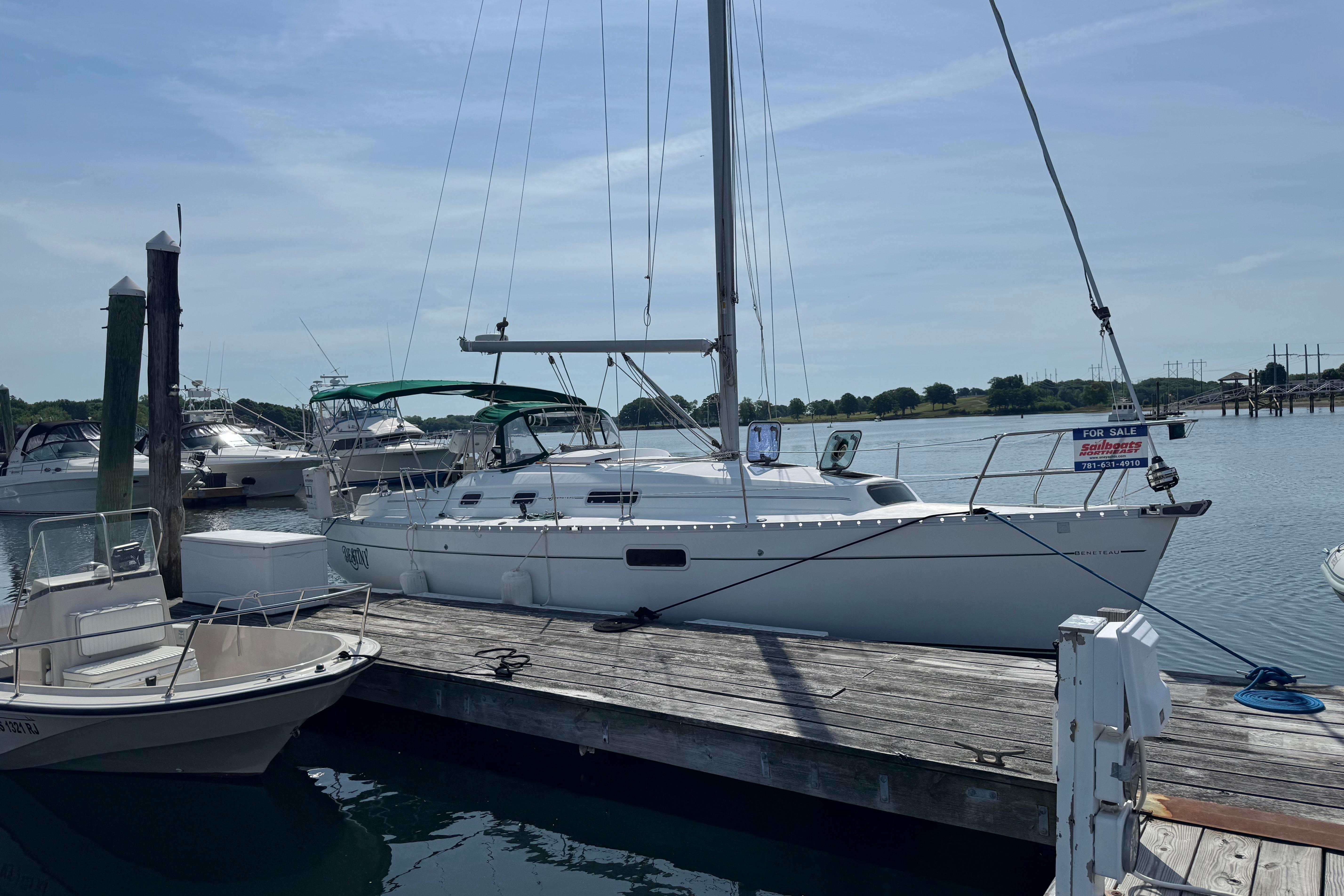 2000 Beneteau Oceanis 321 sailboat docked, for sale sign visible, calm marina setting.