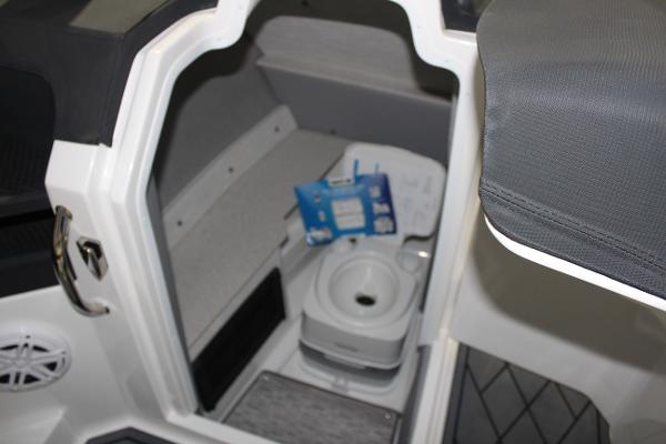 Interior of 2025 Cobalt R6 boat with compact toilet and storage area.