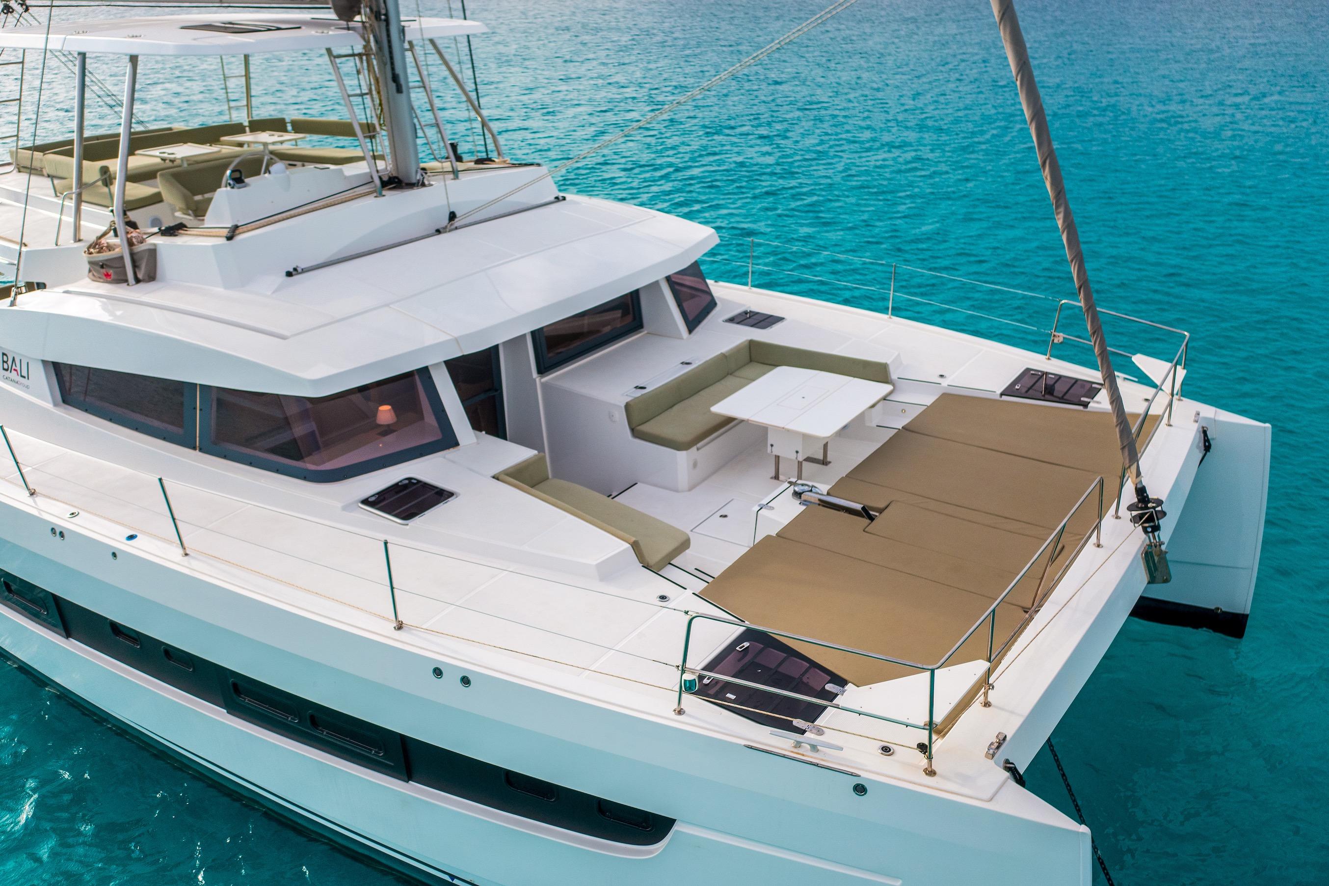 2024 Bali 5.4 catamaran with spacious deck, anchored in clear turquoise waters.