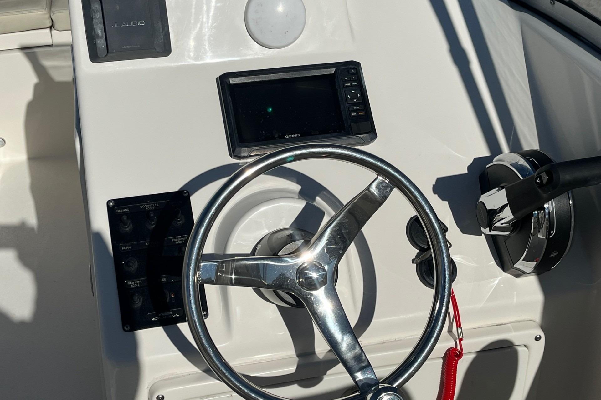 2023 Cobia 220 Dual Console boat helm with steering wheel and controls.