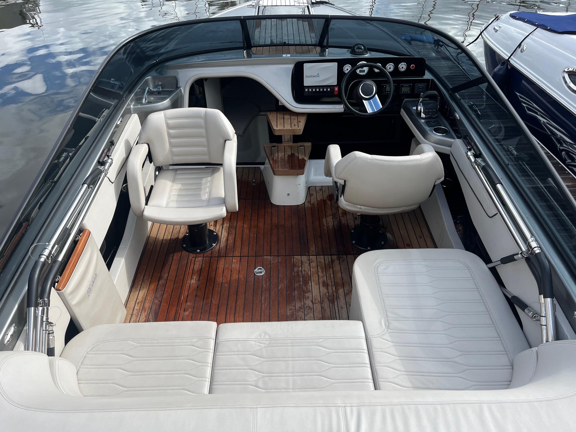 2020 Cranchi E26 Classic boat interior with white seating and wooden flooring.