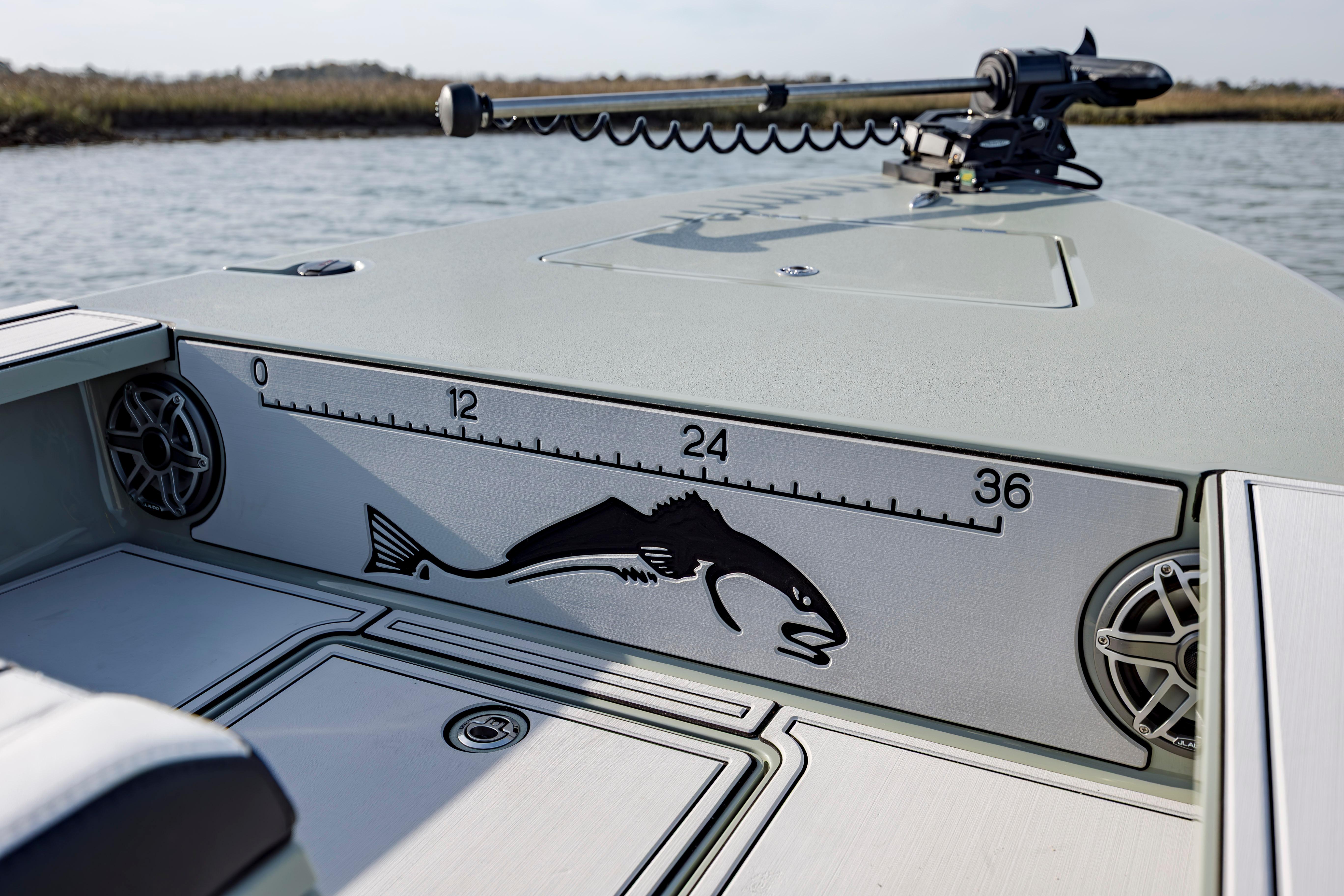 Fishing boat deck with fish ruler, Vtech 18 model, 2025, on calm water.