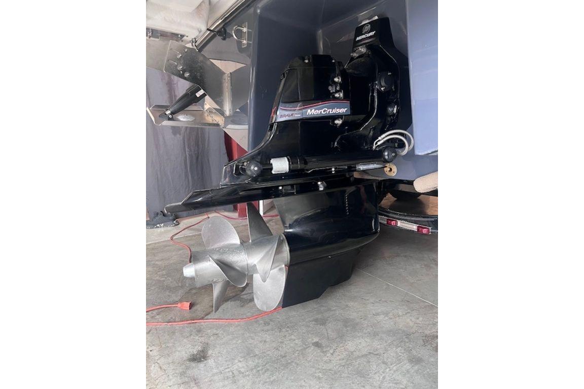 2025 Chaparral 2870 SSX boat with MerCruiser outdrive and dual propellers in a garage setting.