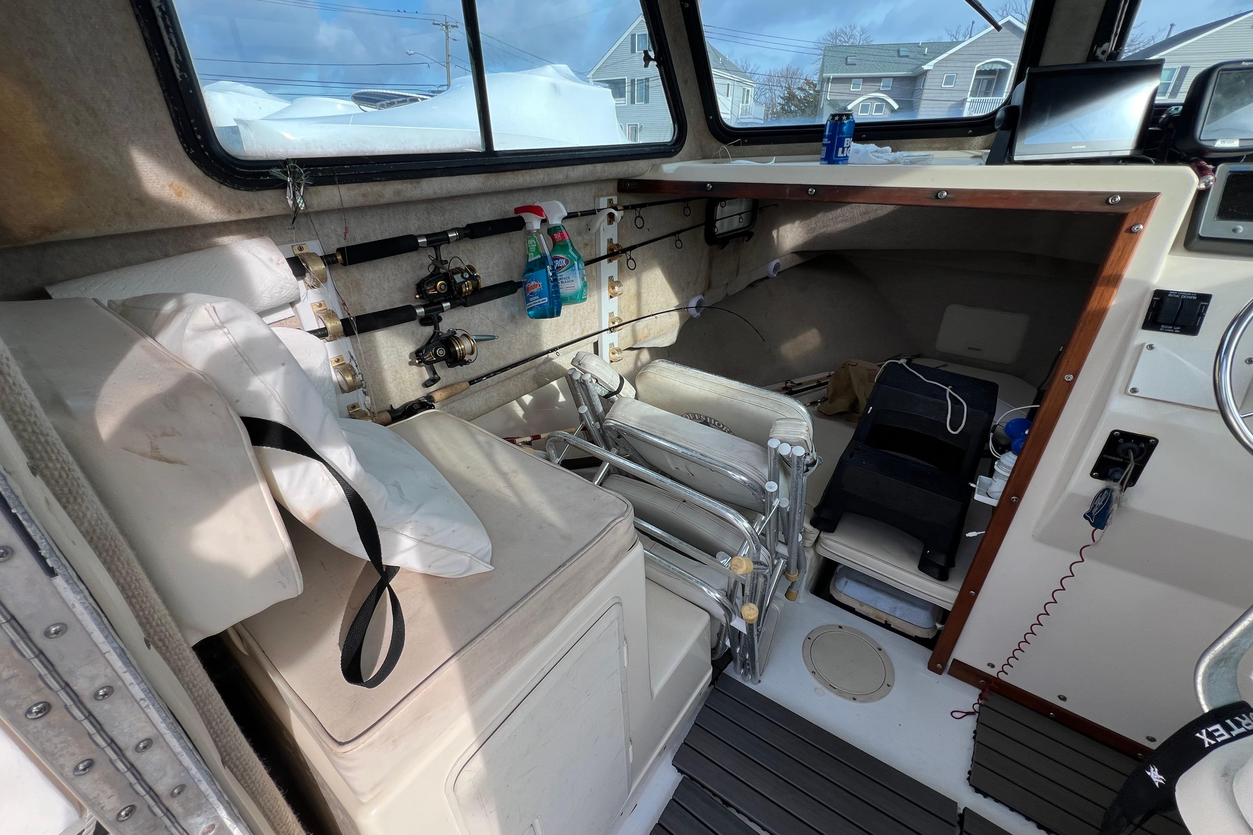 Interior of a 2001 Parker 2520 Deep Vee Sport Cabin with fishing gear and equipment.