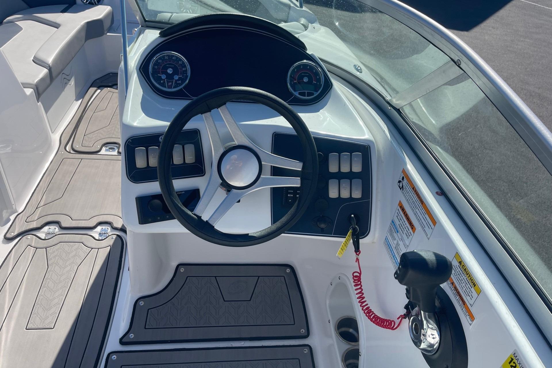 2023 Hurricane SunDeck 2400 OB boat dashboard with steering wheel and controls.