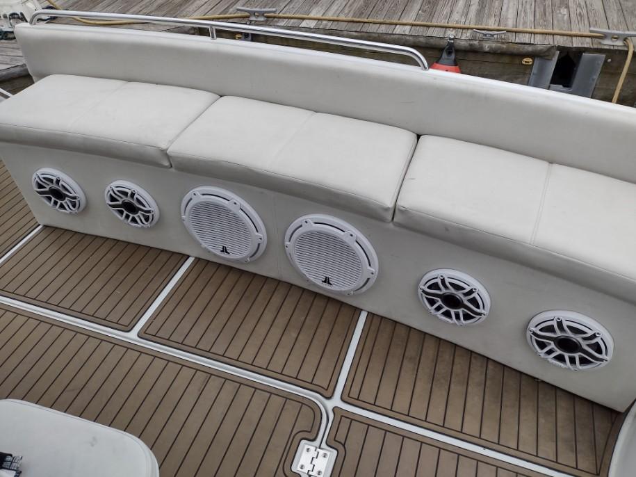 1999 Carver 530 Voyager Pilothouse boat with cushioned seating and built-in speakers.