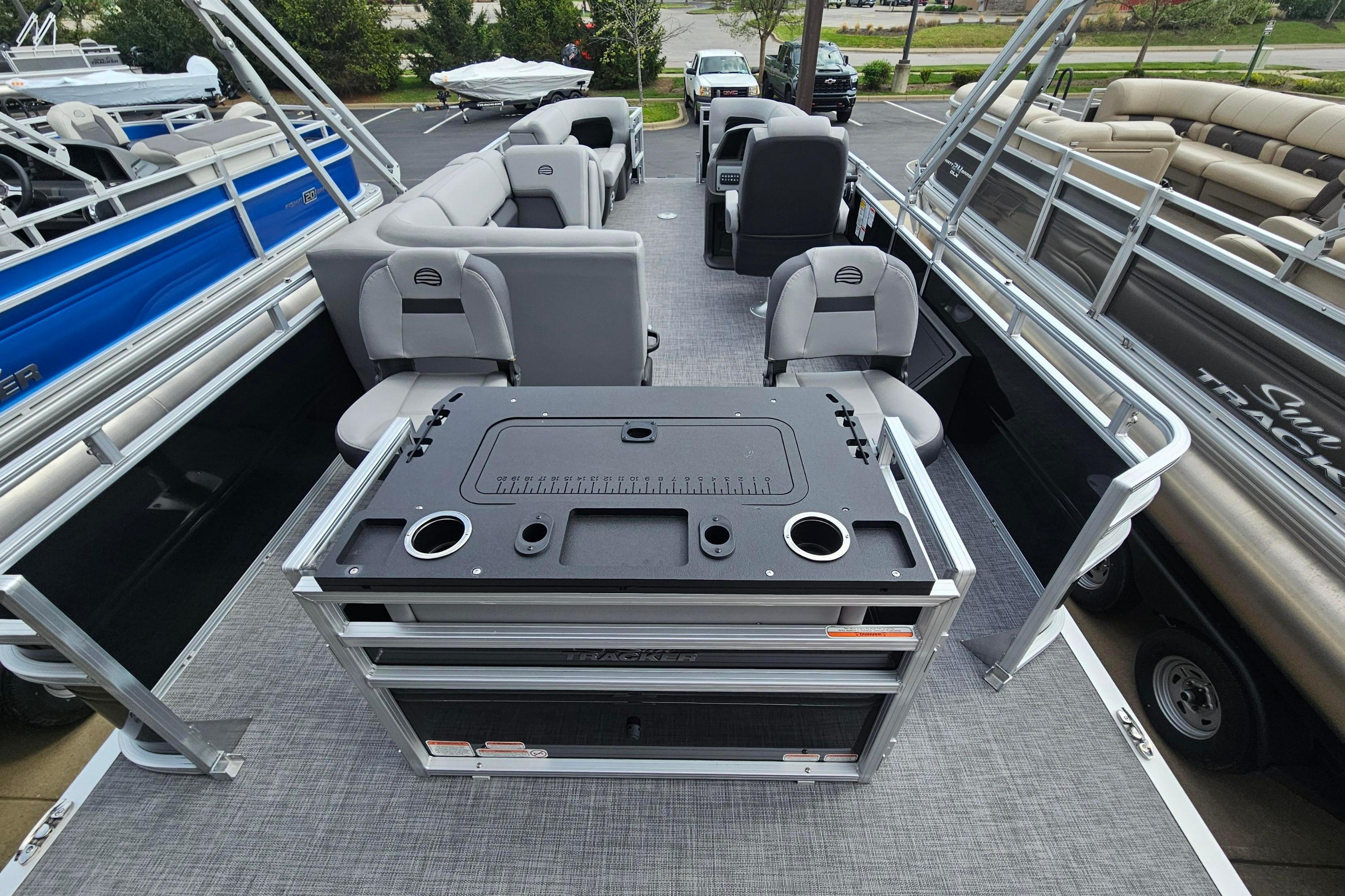 2026 Sun Tracker SportFish 22 DLX pontoon boat interior with seating and fishing station.