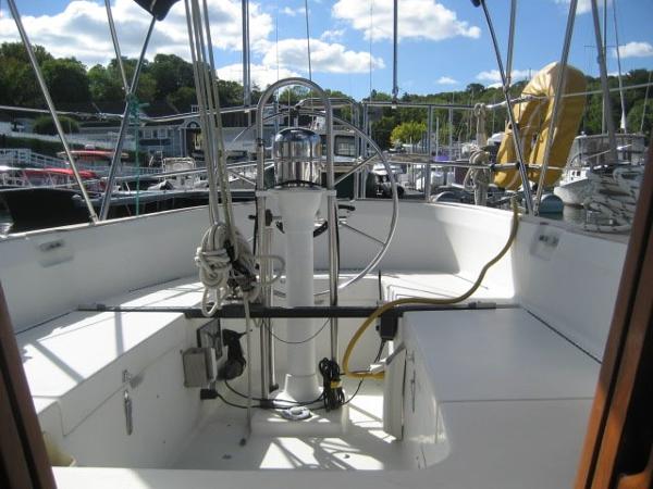 The cockpit of a C&C Landfall yacht in a marina, featuring a steering wheel and rigging.